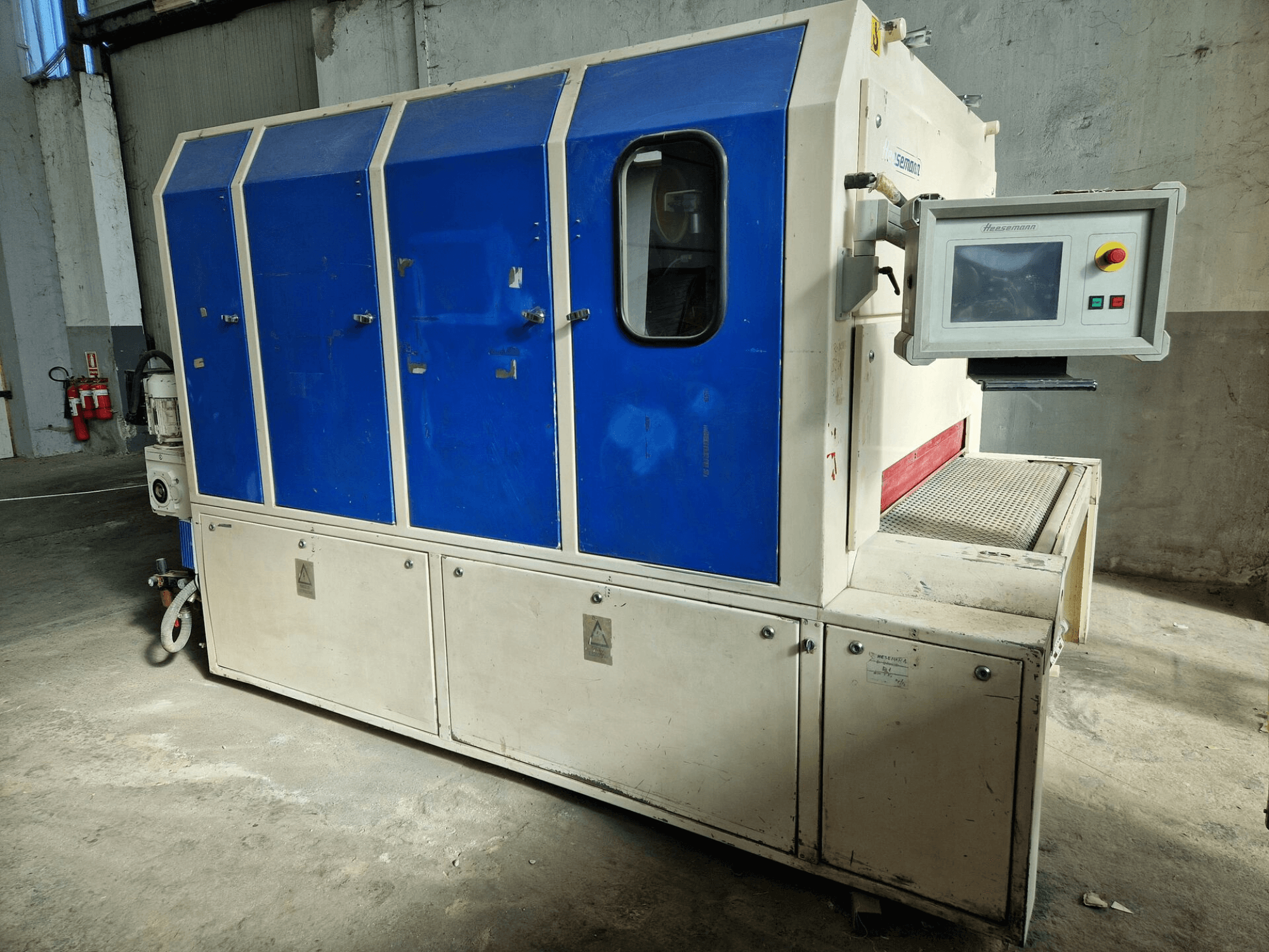 Industrial machine from brand "Sedecom," side view; features blue panels, a control screen, and a textured surface for handling products.