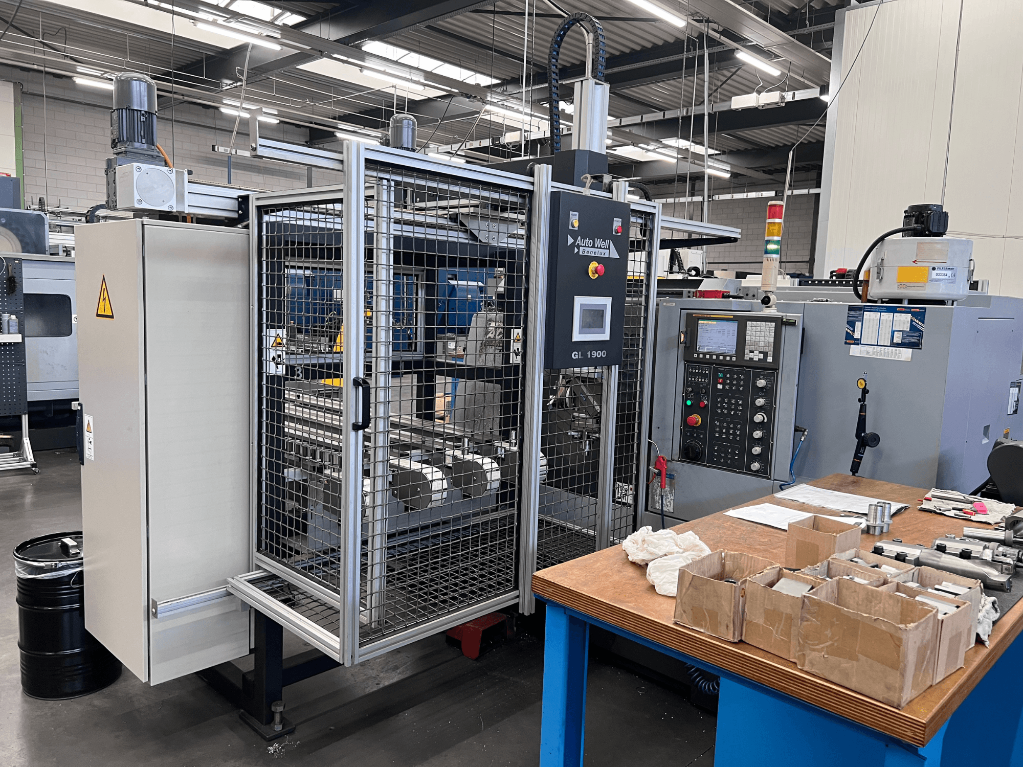 Front view of Auto Weld GL 1900 machine with control panel, safety enclosure, and surrounding tools on a workbench.