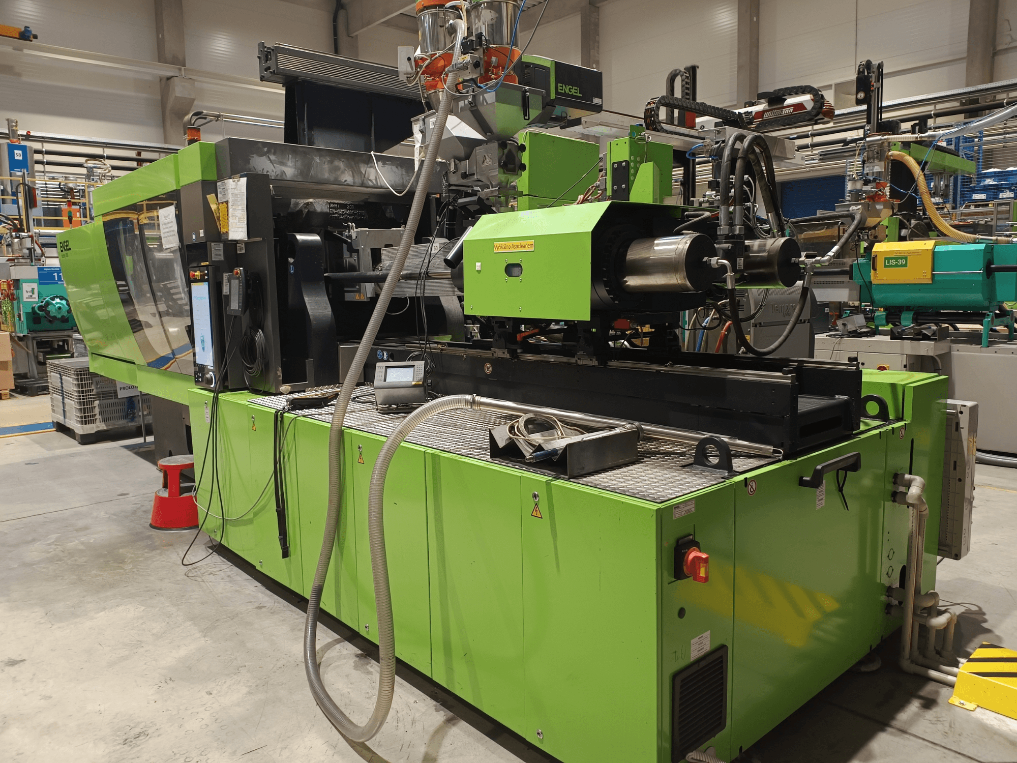 Engel injection molding machine, side view, green exterior, with touchscreen panel and hydraulic components visible.