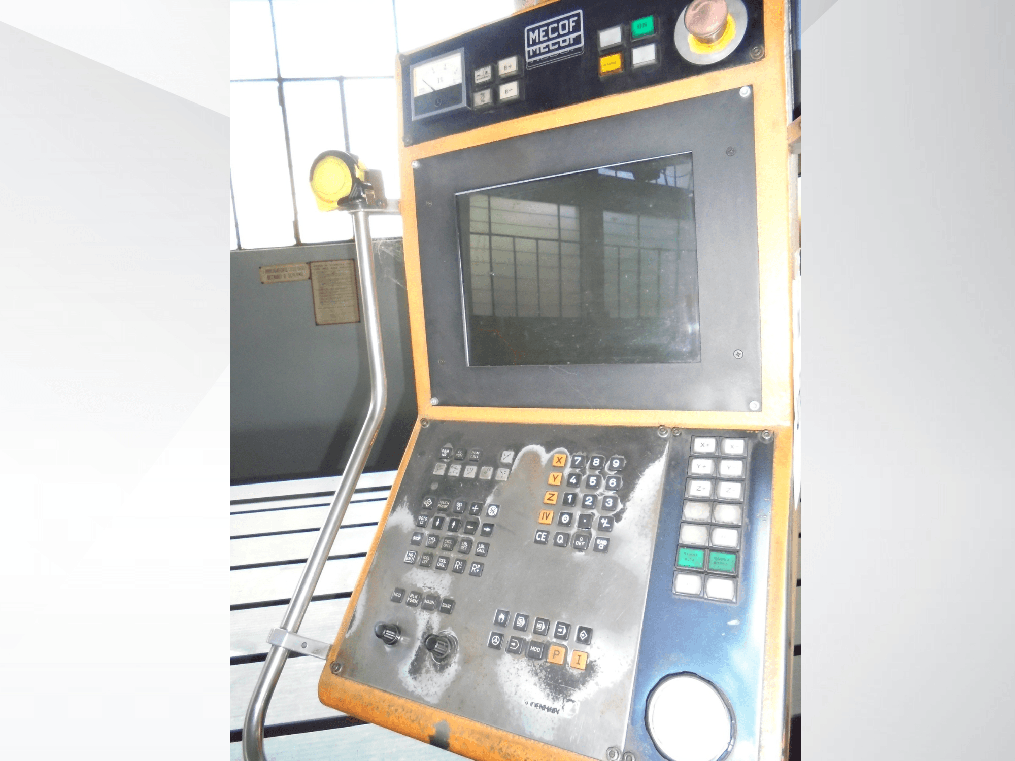 Mecof control panel featuring a digital display, buttons, and knobs; front view showing wear and tear on controls.