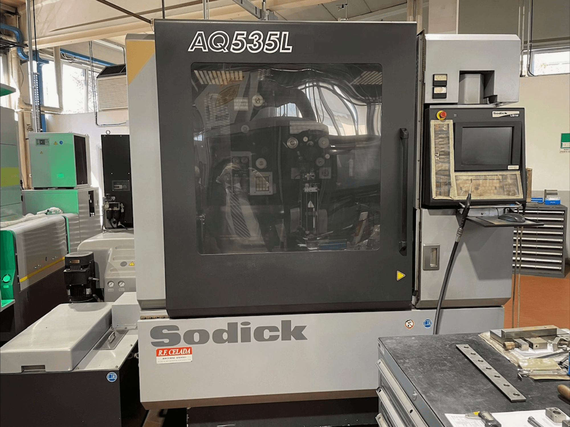Sodick AQ535L Wire EDM machine front view, featuring control panel and transparent protective cover.