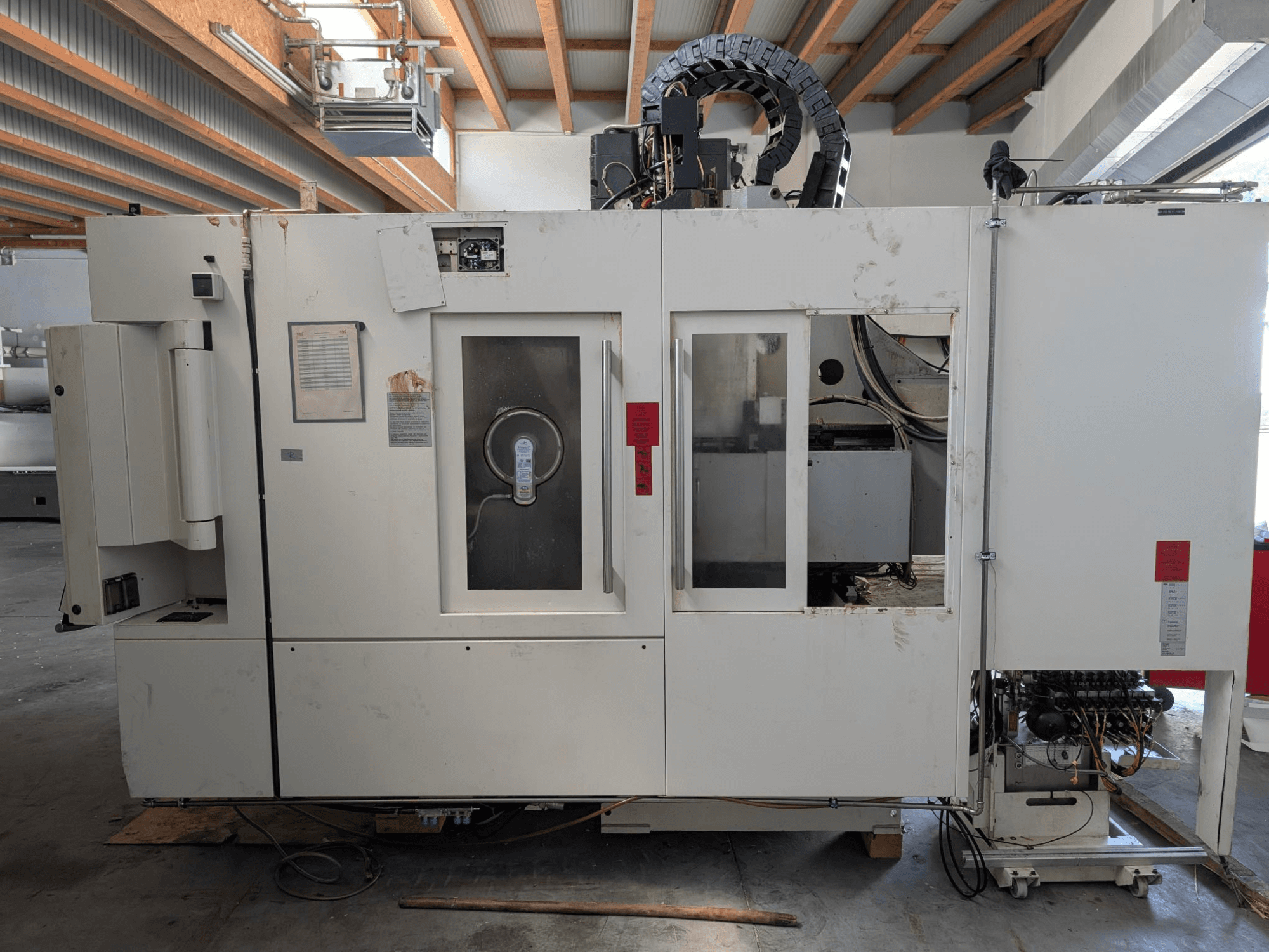 STAMA MC 326 vertical machining center, side view showing control panel, spindle area, and various labels on the machine.