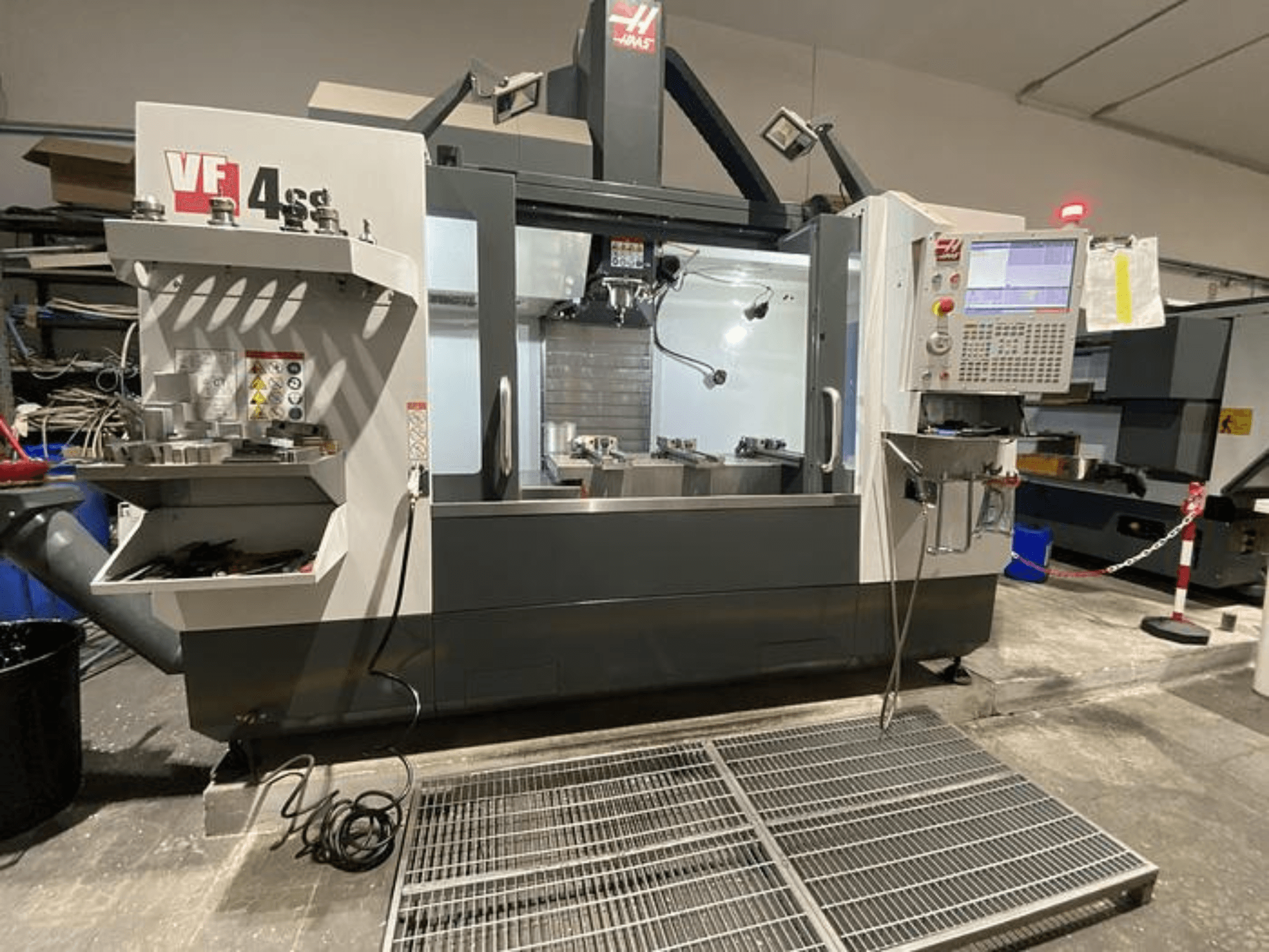Haas VF-4SS CNC milling machine, front view, with tool storage, control panel, and visible work area in a workshop setting.