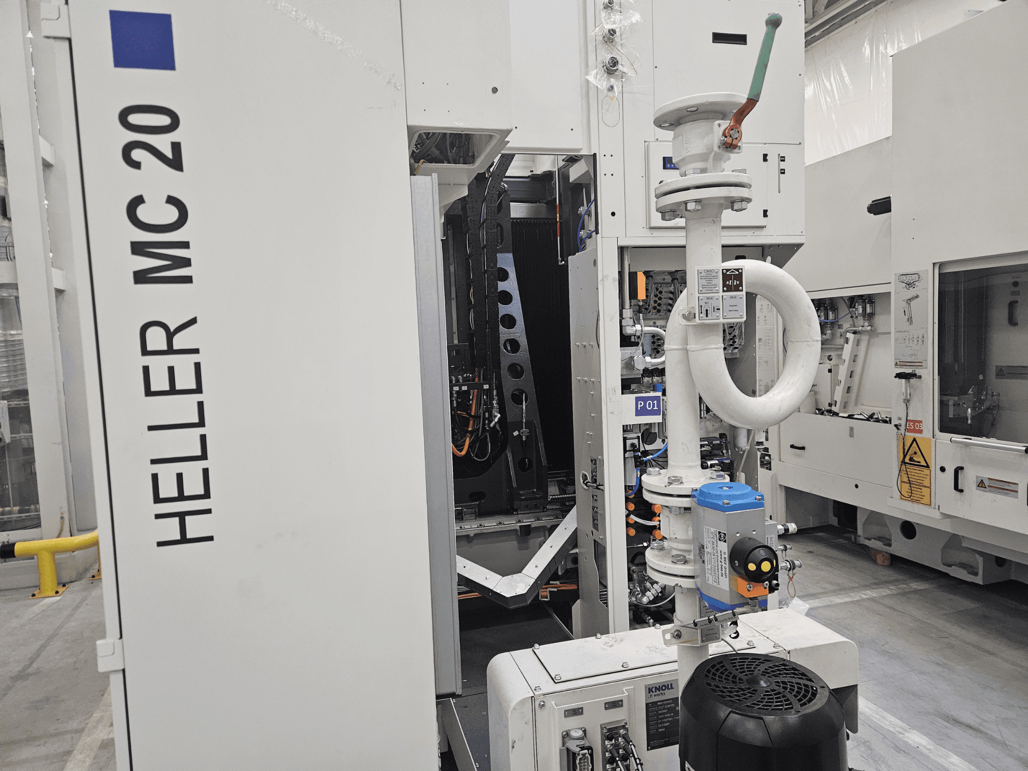 Heller MC 20 machine in a factory setting, showcasing control panel and mechanical components from a side view.
