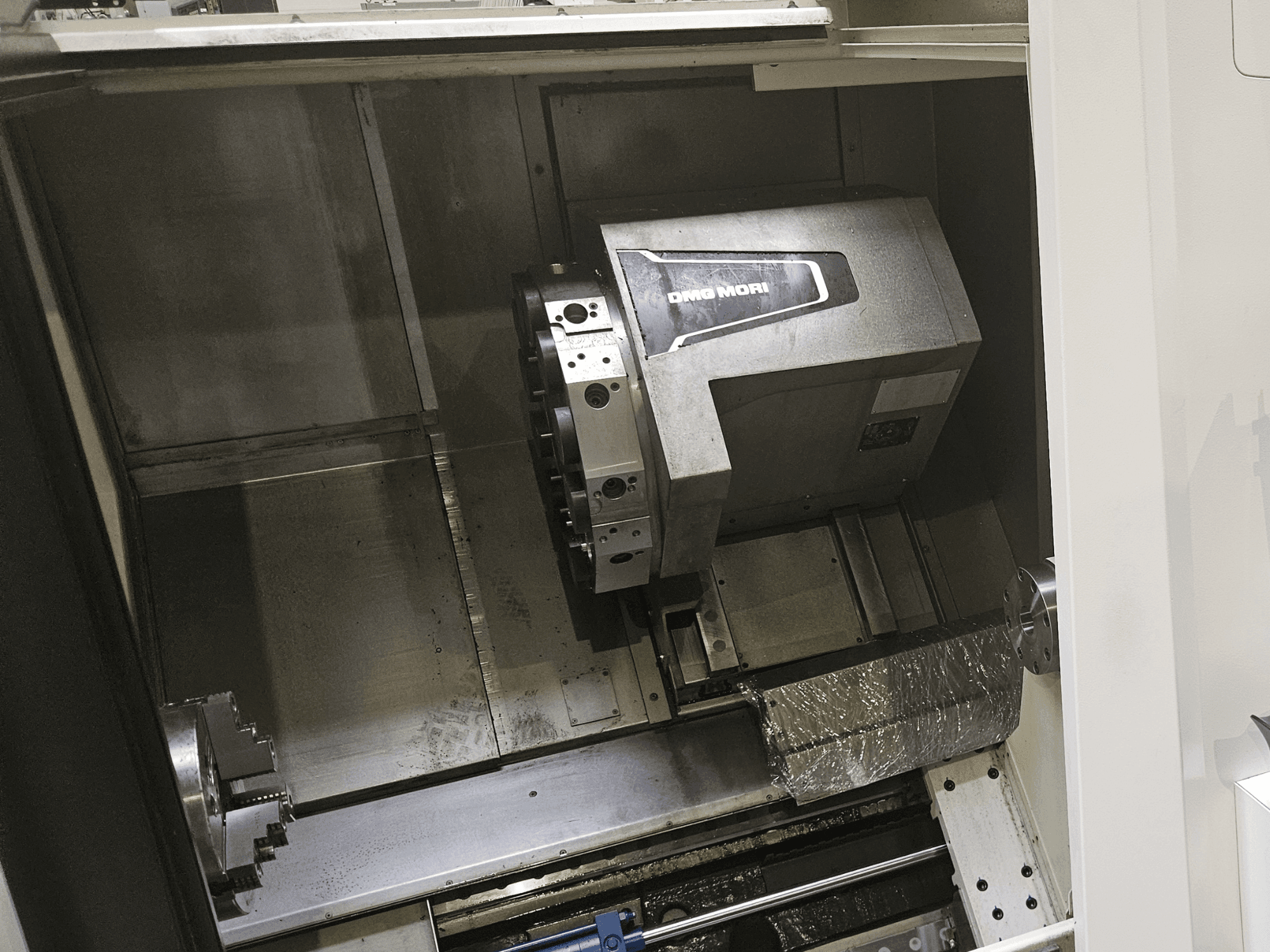DMG MORI CLX 450 V4 horizontal turning machine interior view, showcasing the spindle and control interface.