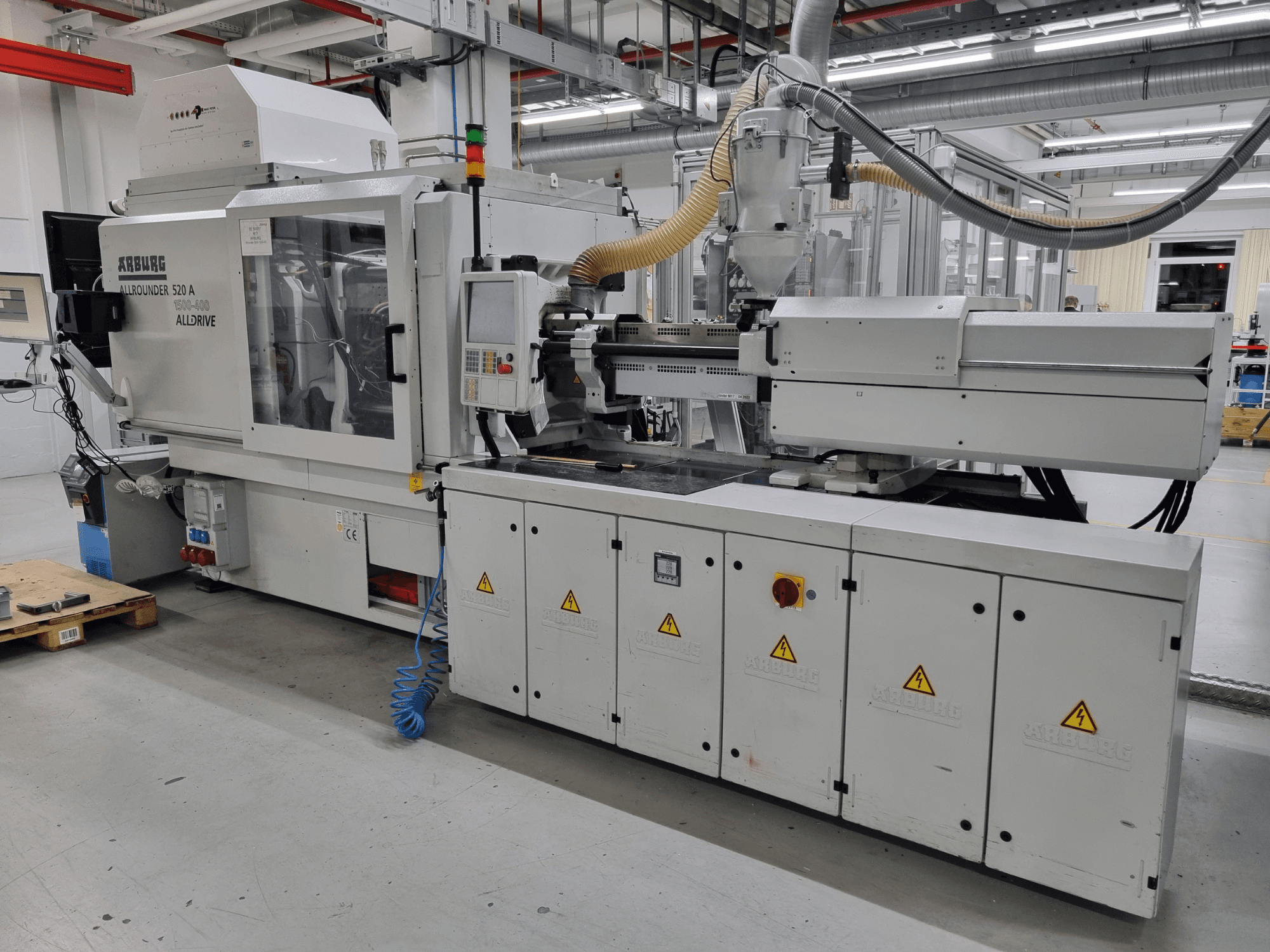 Arburg Allrounder 520 A injection molding machine, side view, showcasing control panel and safety features.