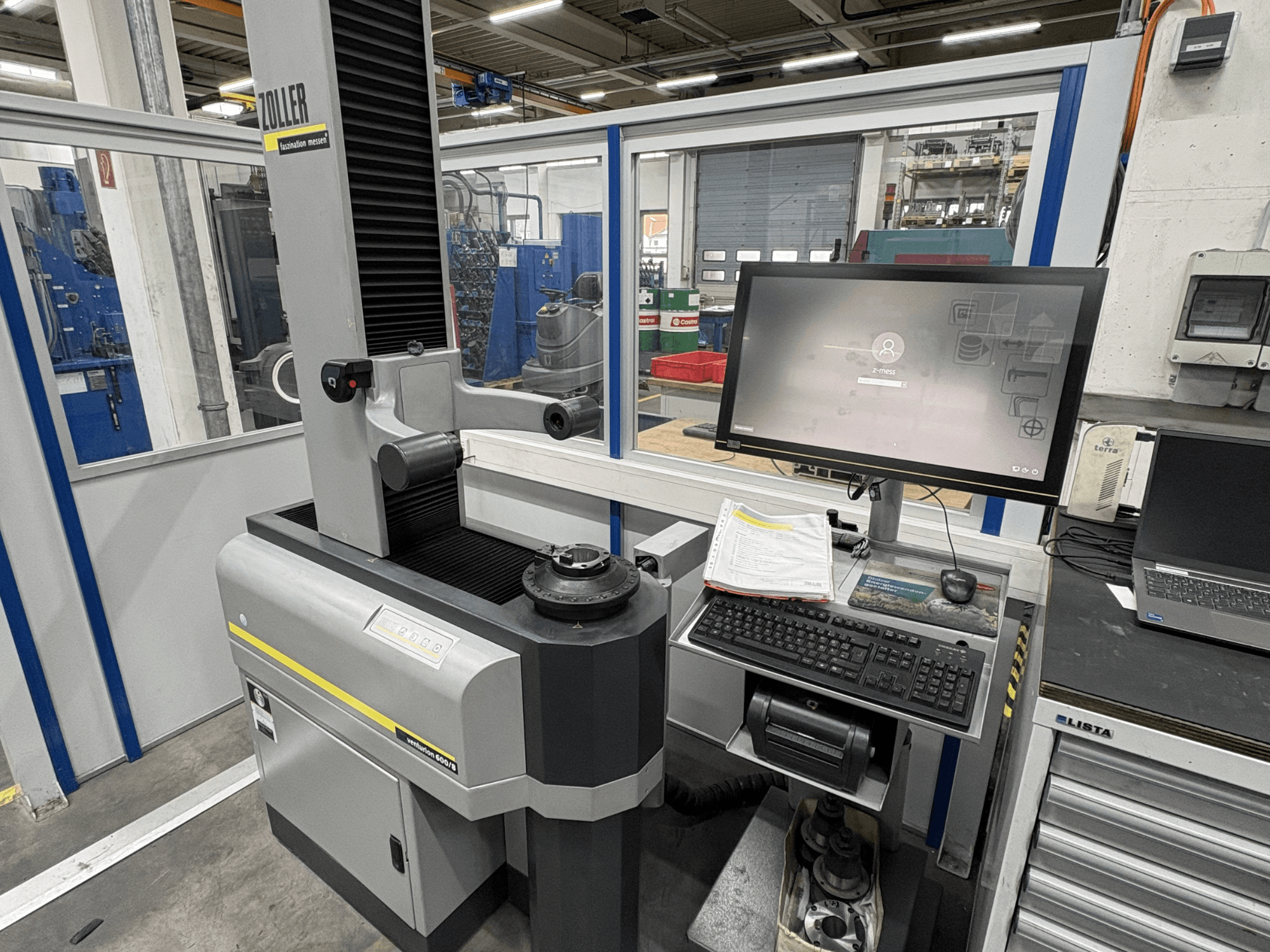 Zoller Venturion 600/8 optical measurement machine in a workshop, featuring a monitor, keyboard, and measurement platform in side view.
