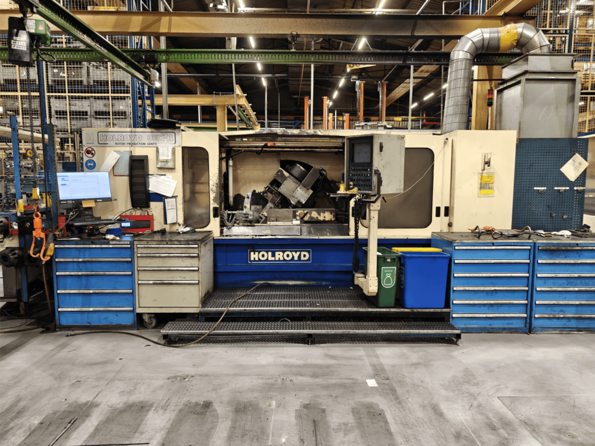 Holroyd 3EX-R machine tool in a workshop, front view, showing control panel, tool storage, and work area inside.