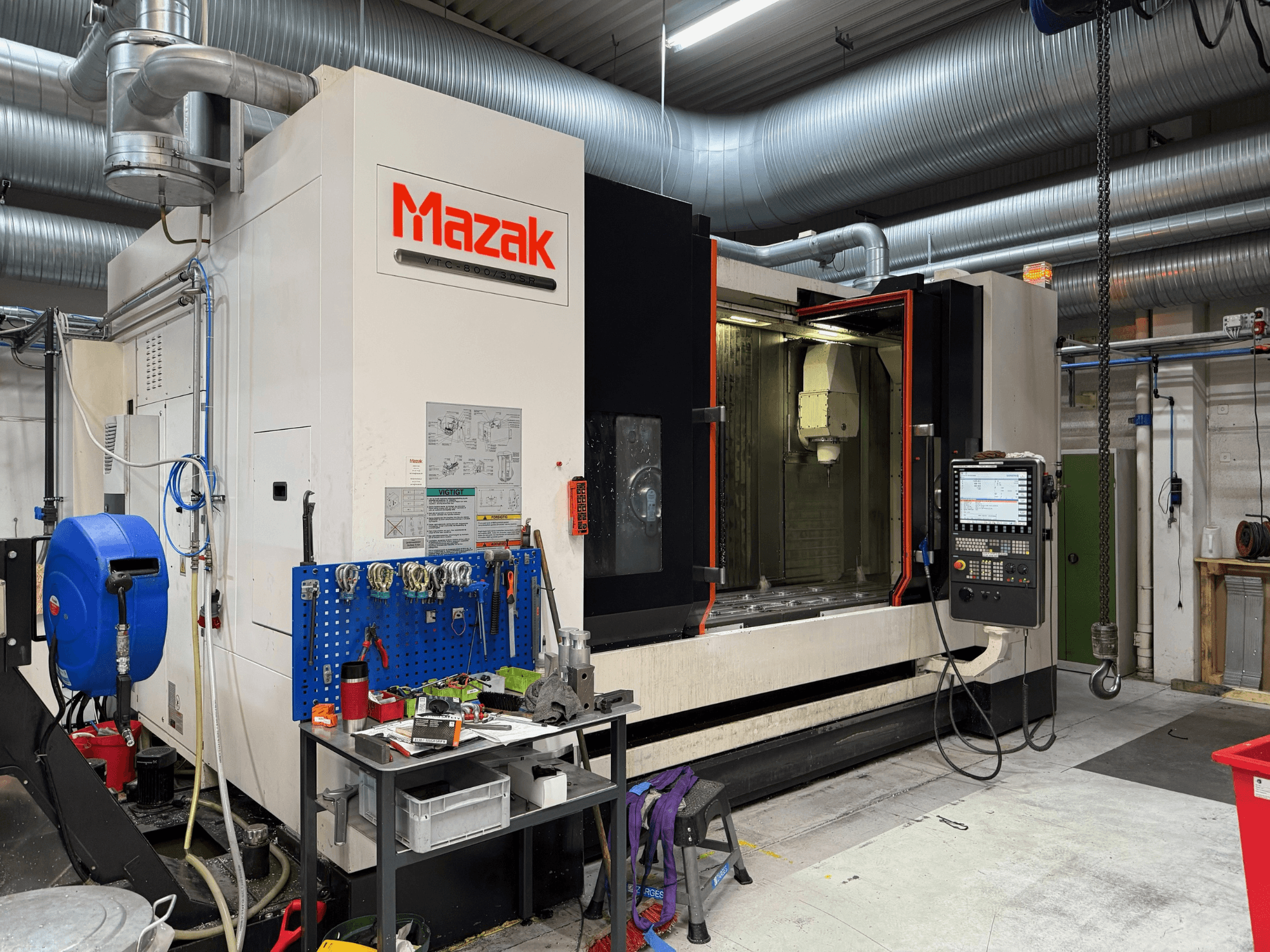 Mazak CNC machine from a front view, featuring controls, tools, and workspace in a machining environment.