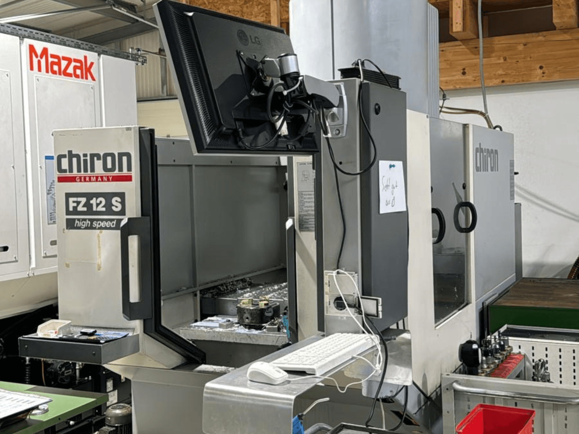 Vertical view of CHIRON FZ 12 S high speed machining center with control screen and debris from machining process.