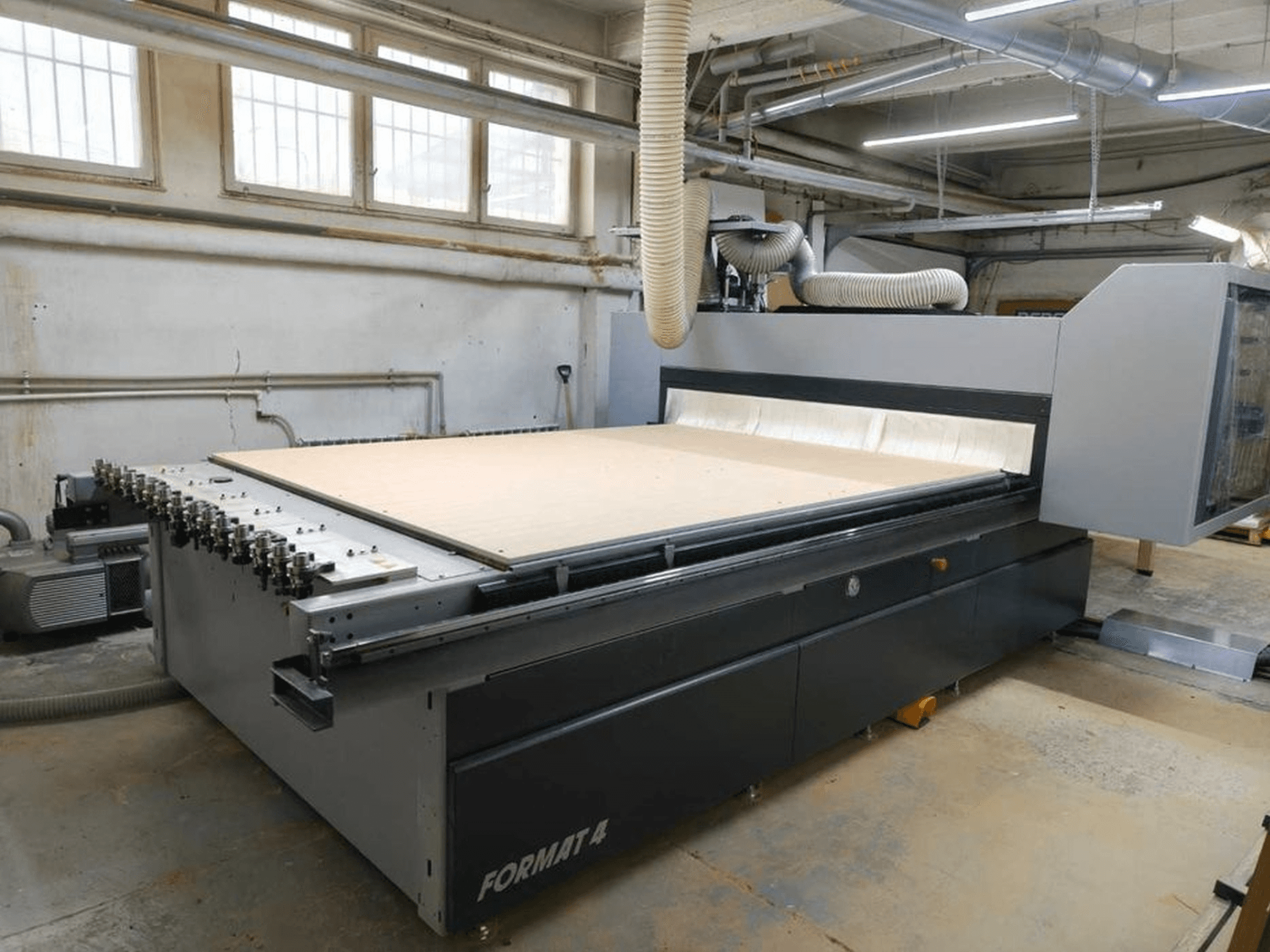 CNC Router FORMAT4 Profit H80 21.31 in workshop, side view with a large cutting surface and visible hose for dust extraction.