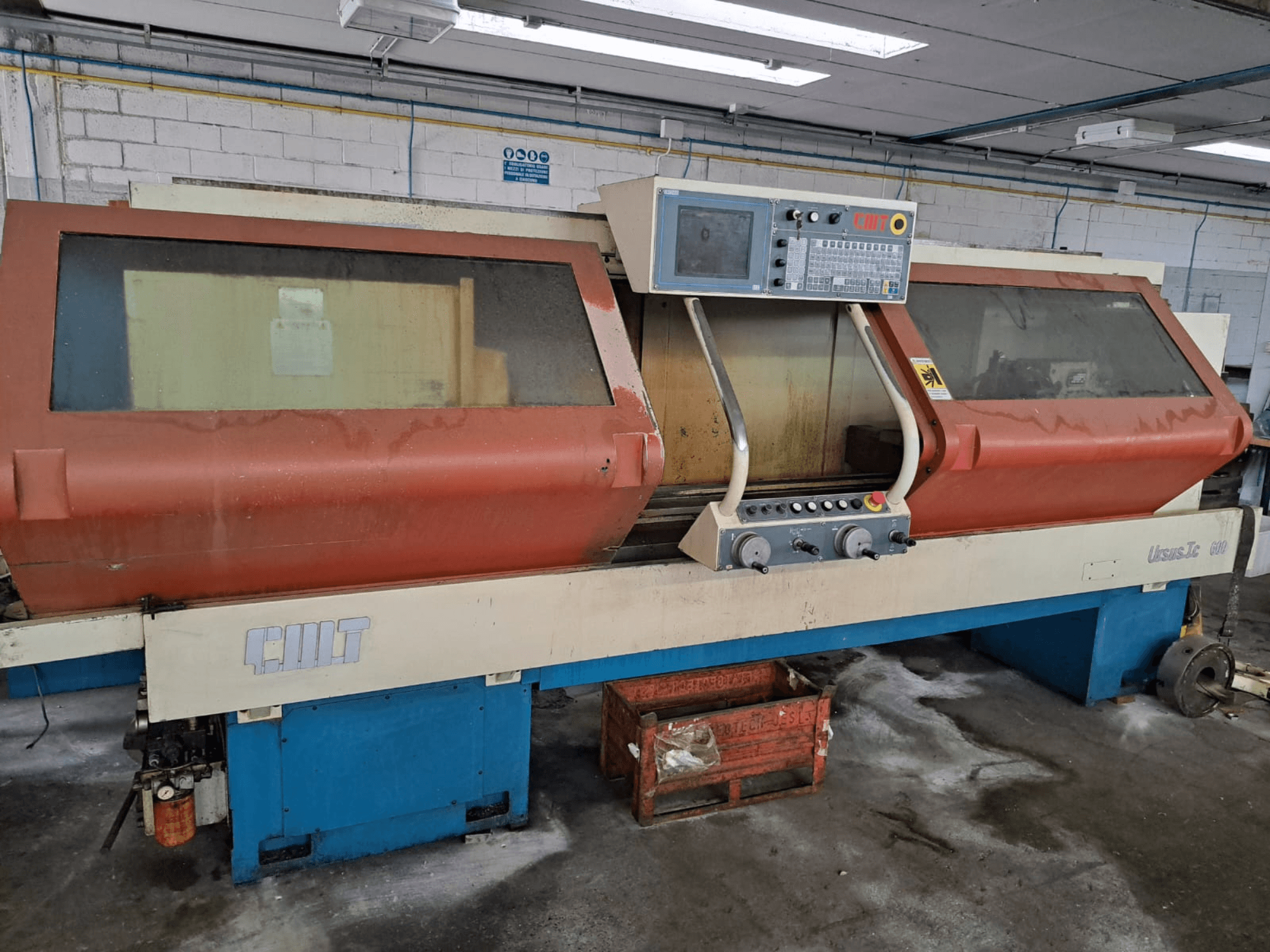 Horizontal turning machine URSUS TC, front view, with red housing, control panel, and visible tool holder.