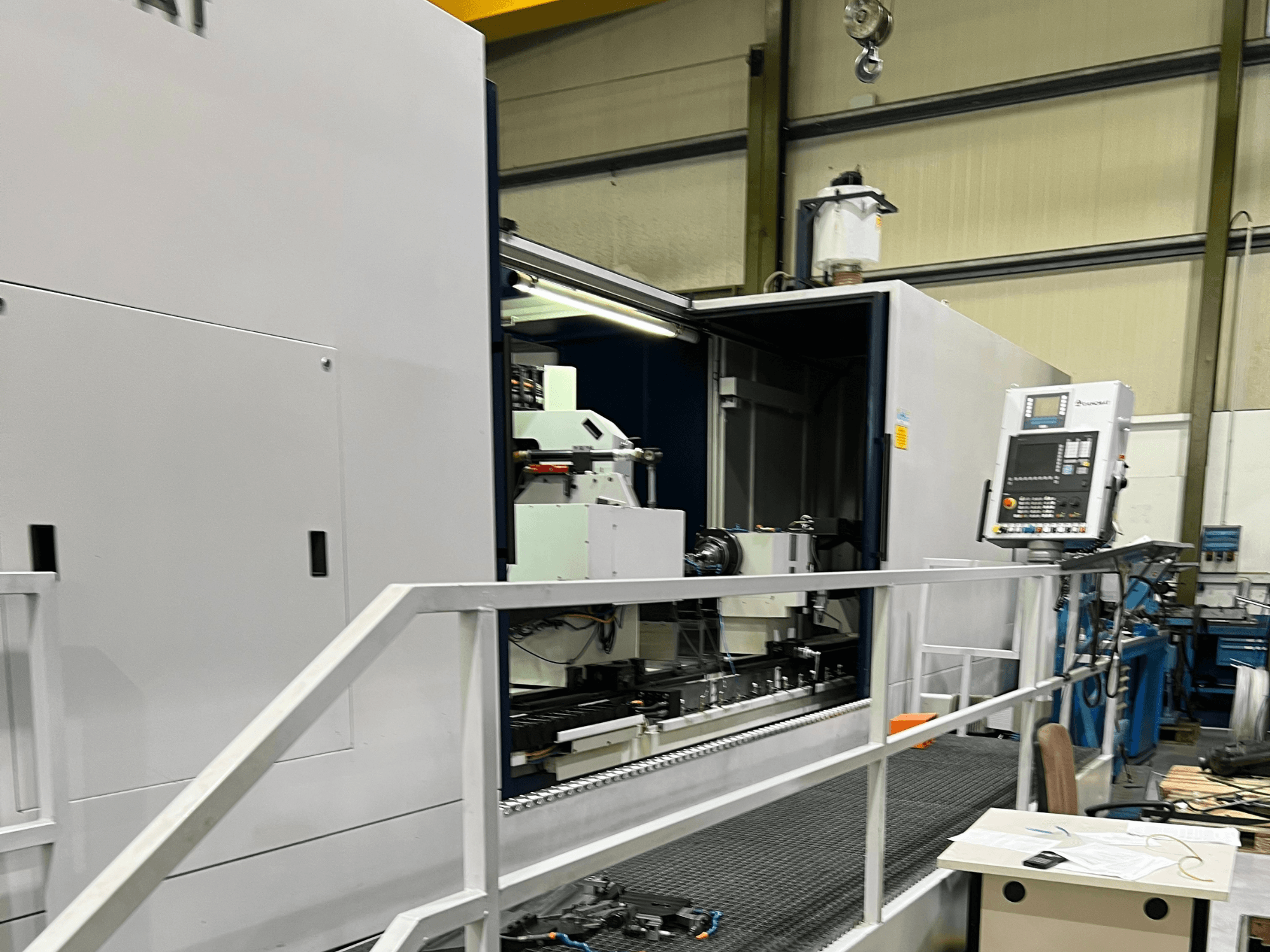 CNC machining center with open side view, showcasing controls, tool holder, and main component inside. Brand details not visible.