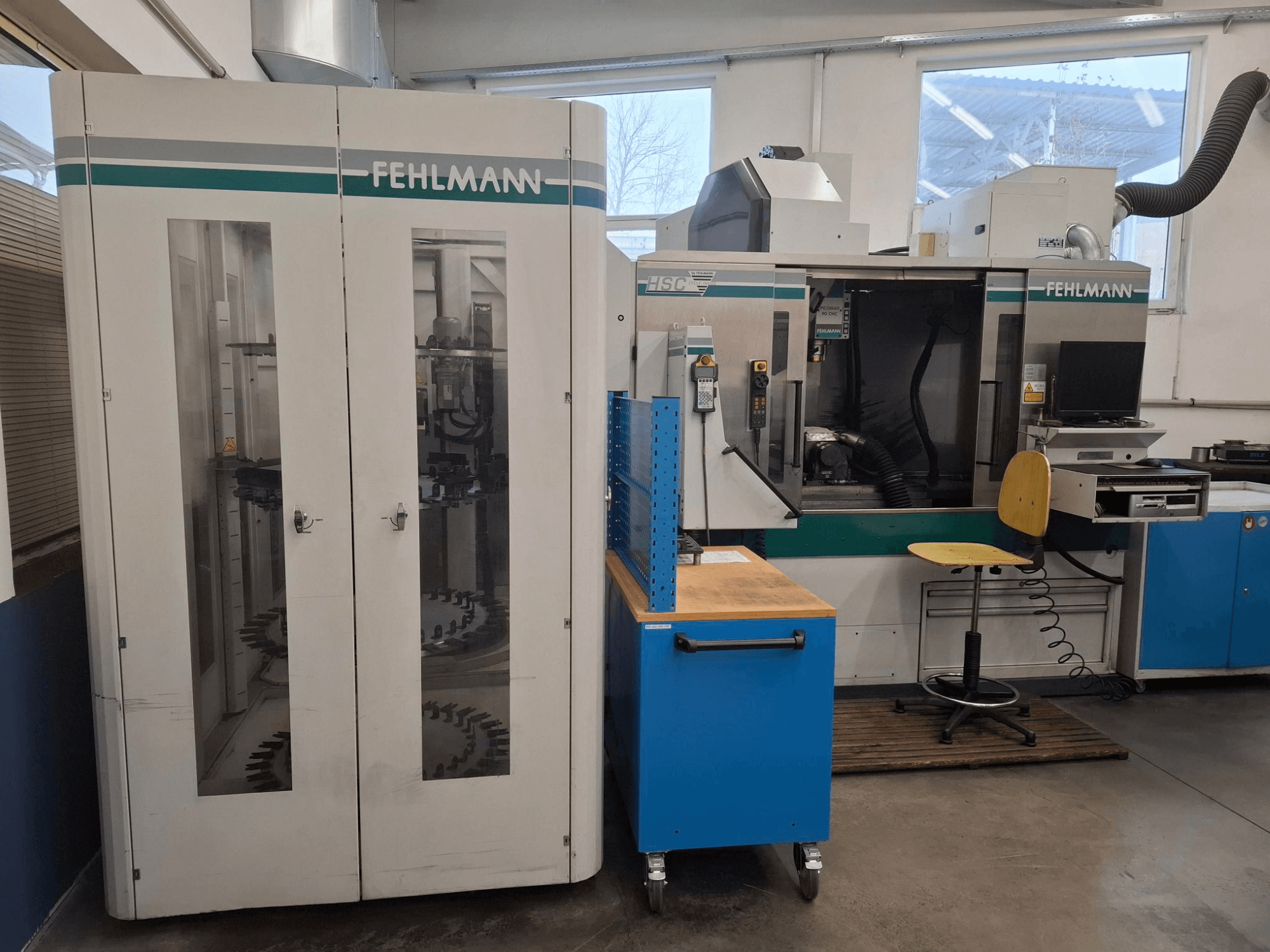 FEHLMANN HSC machining center in a workshop; front view with visible controls, seating, and tool storage.
