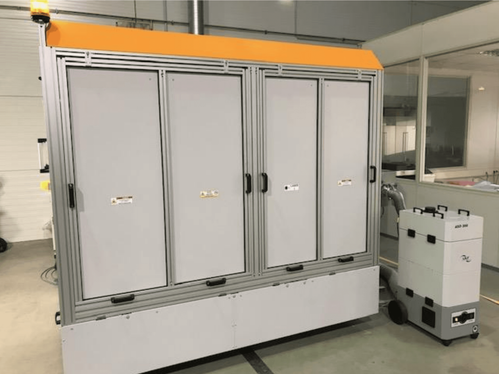 4JET Pearl M fiber laser cutting machine, front view, with safety light, control panel, and connected extraction unit visible.