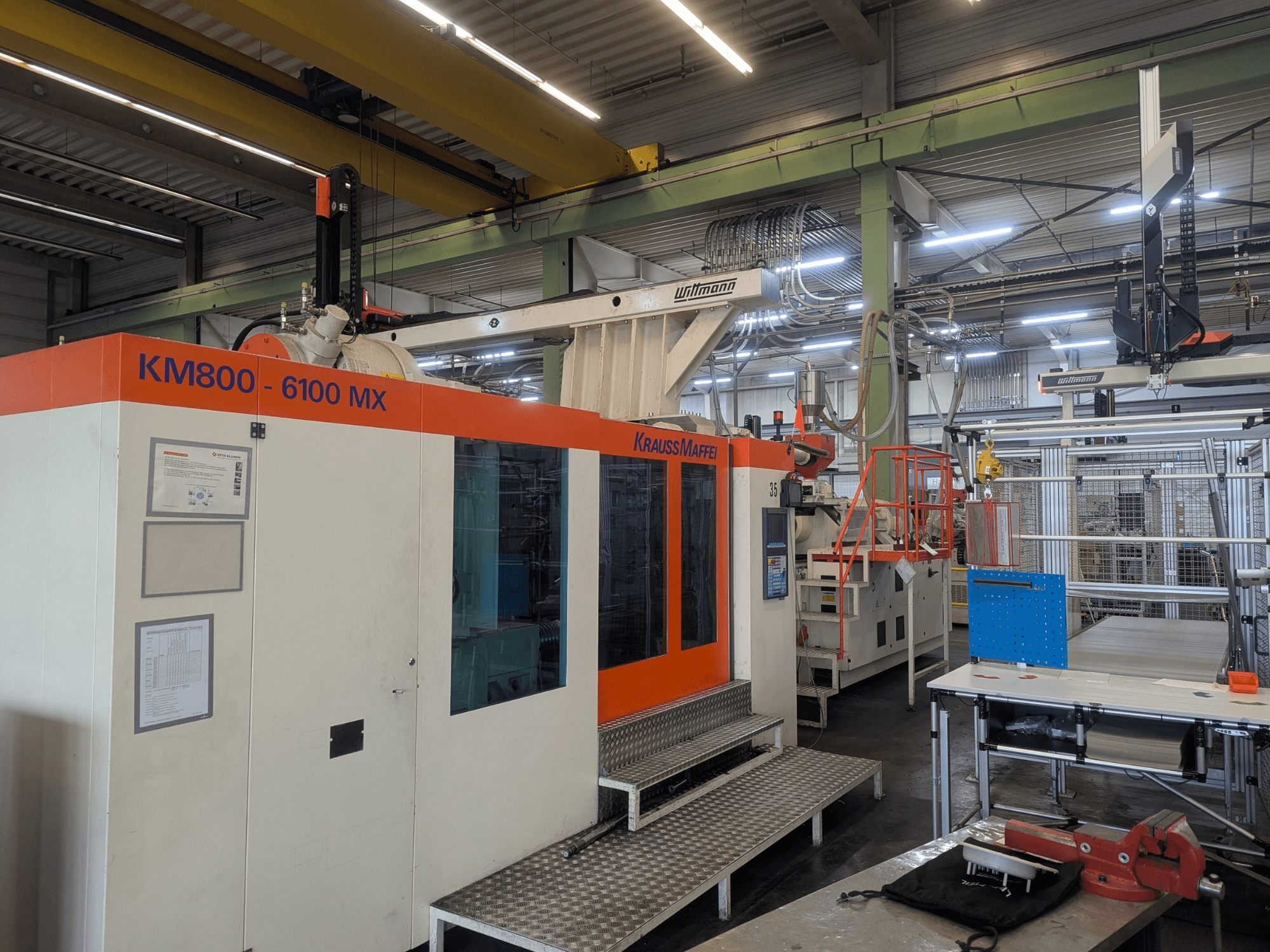 Krauss Maffei KM 800-6100MX hydraulic injection molding machine, front view, showcasing control panel and industrial setup.