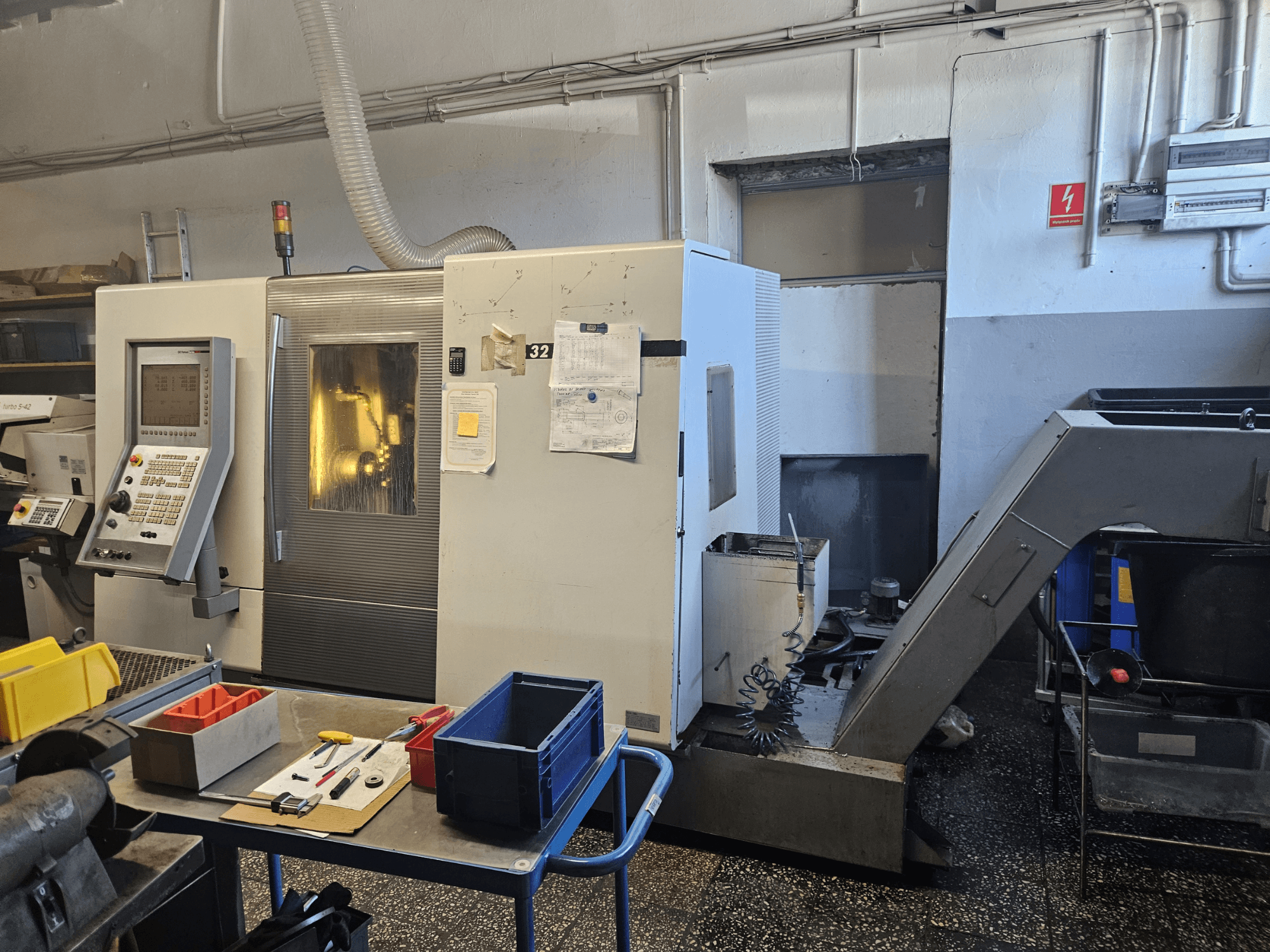 Multi-spindle turning machine DMG GILDEMEISTER Sprint 32 linear, front view in a workshop, with control panel and tools visible.