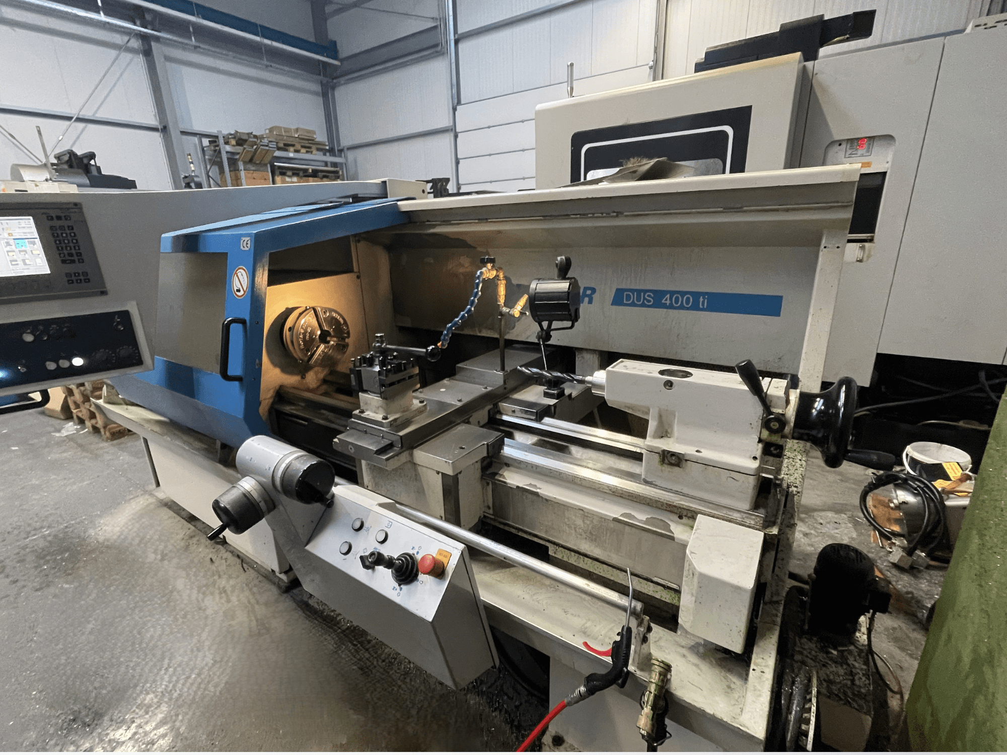 CNC lathe machine DUS 400 ti from front view, featuring control panel, tool holder, and illuminated workspace.
