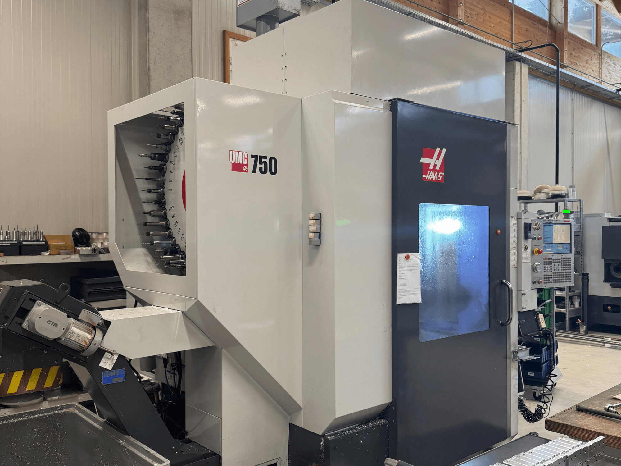 Haas UMC 750 machining center, front view, showcasing tool holder and control panel in a workshop setting.