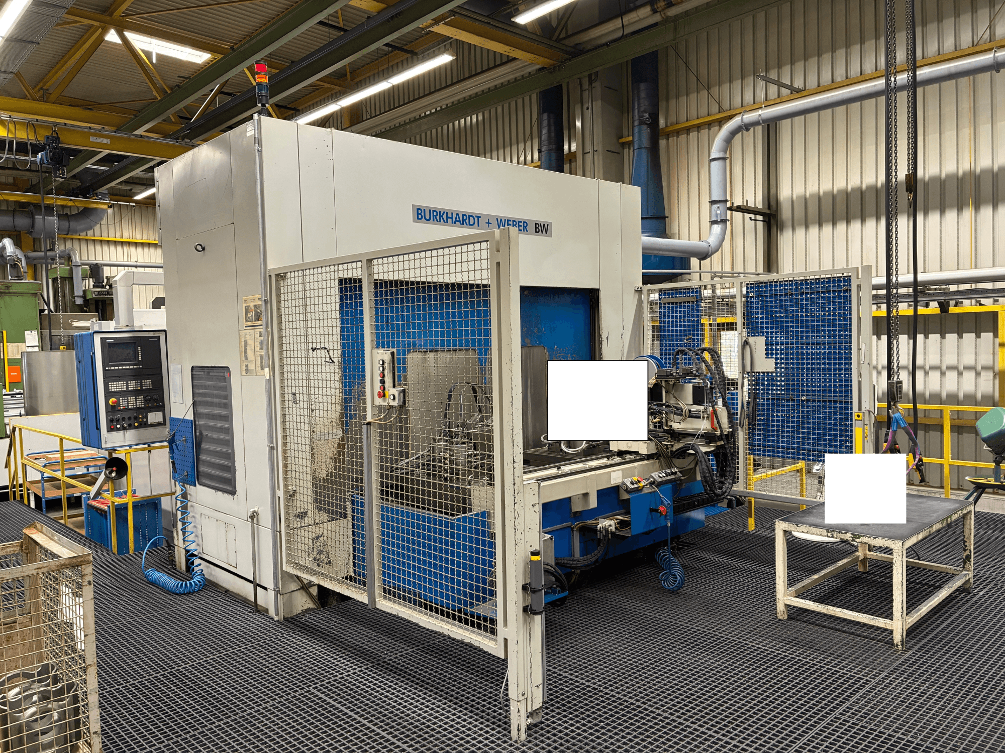 Burkhardt + Weber BW machining center, front view, features control panel and safety enclosure, located in industrial setting.