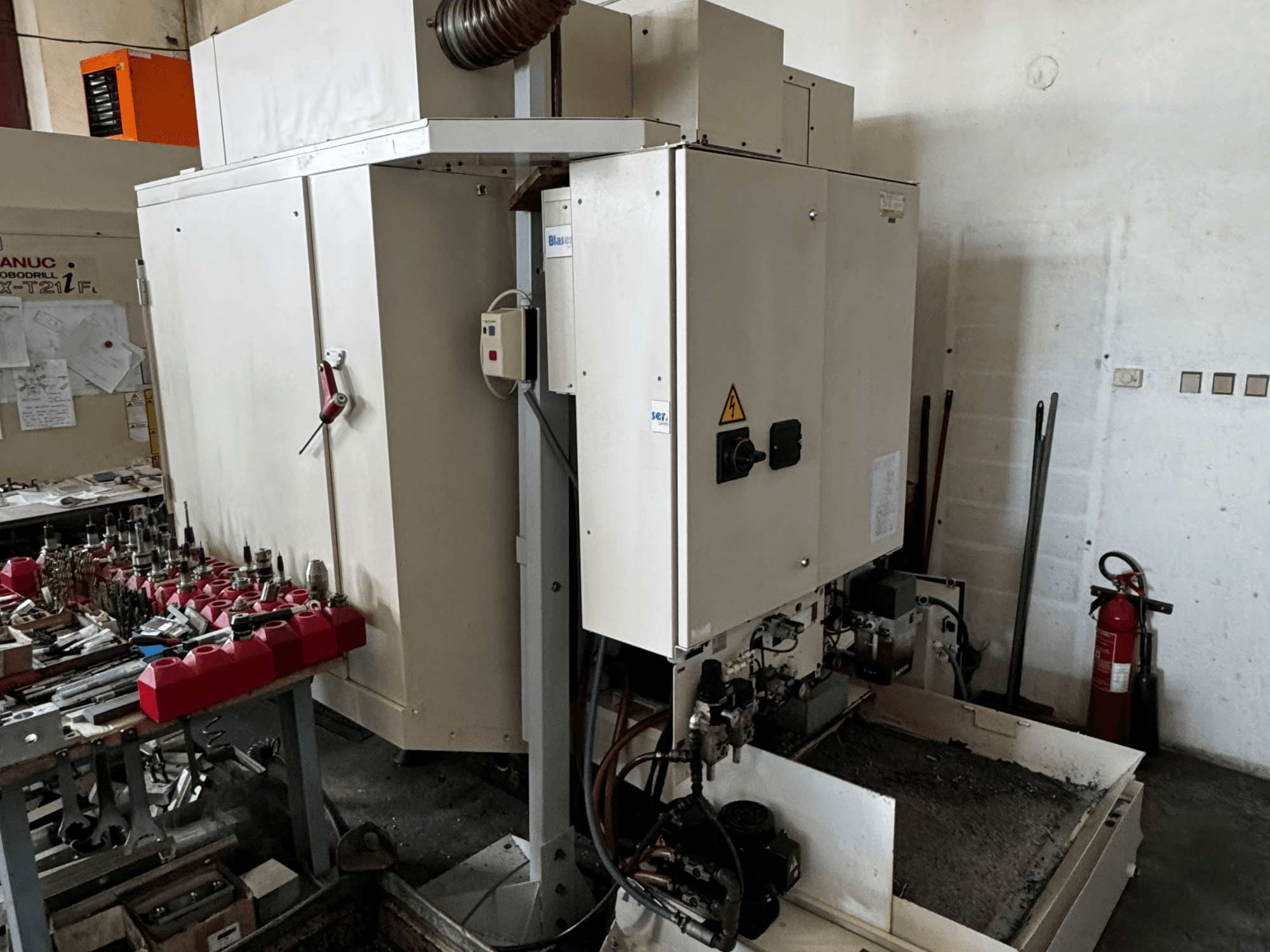FANUC Robodrill alpha-T21iFL vertical machining center, side view showing control panel, tools, and workspace.