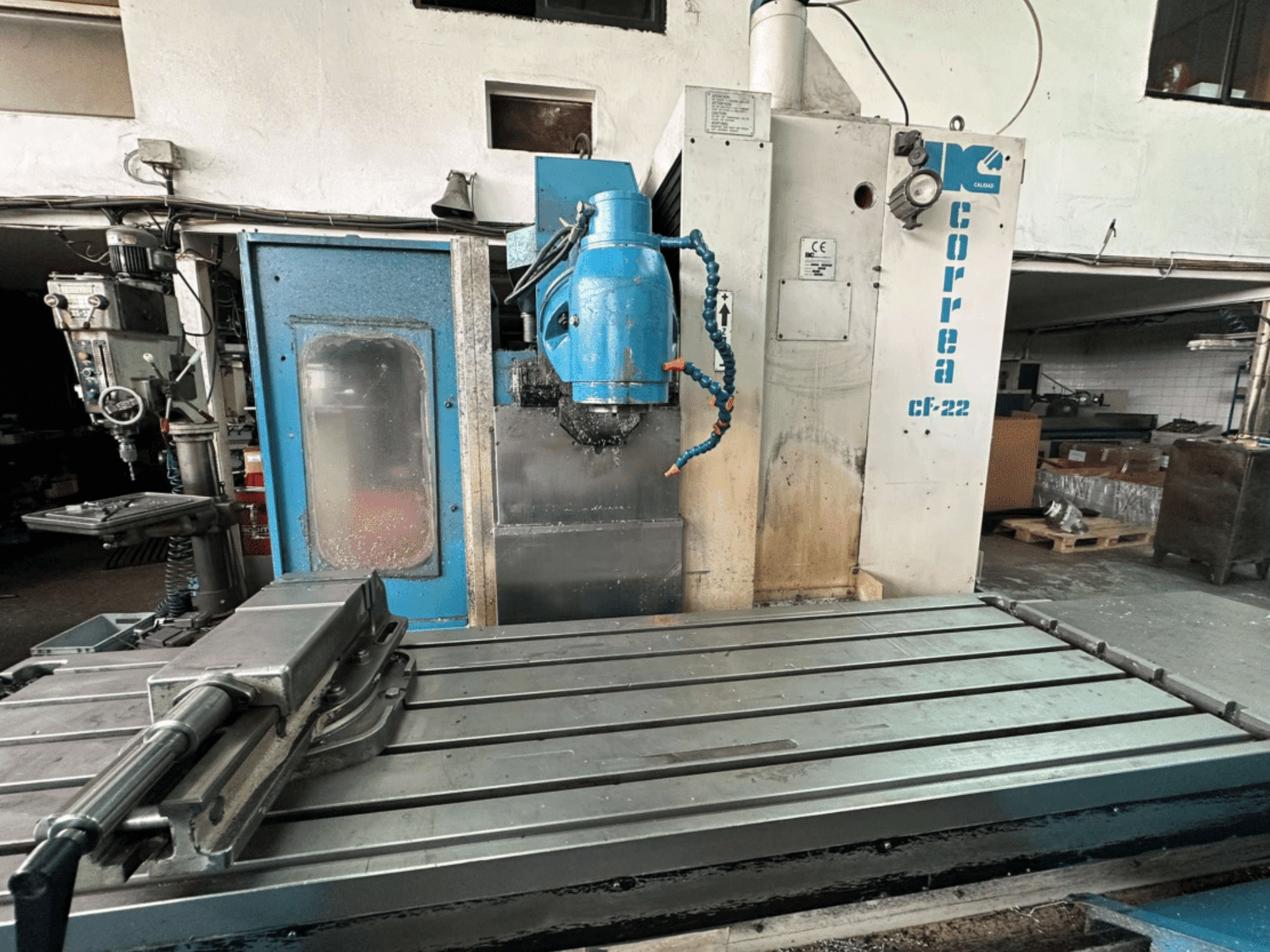 Correa CF-22 milling machine shown from a front view, featuring a blue and silver design, with a sliding table and cutting head.