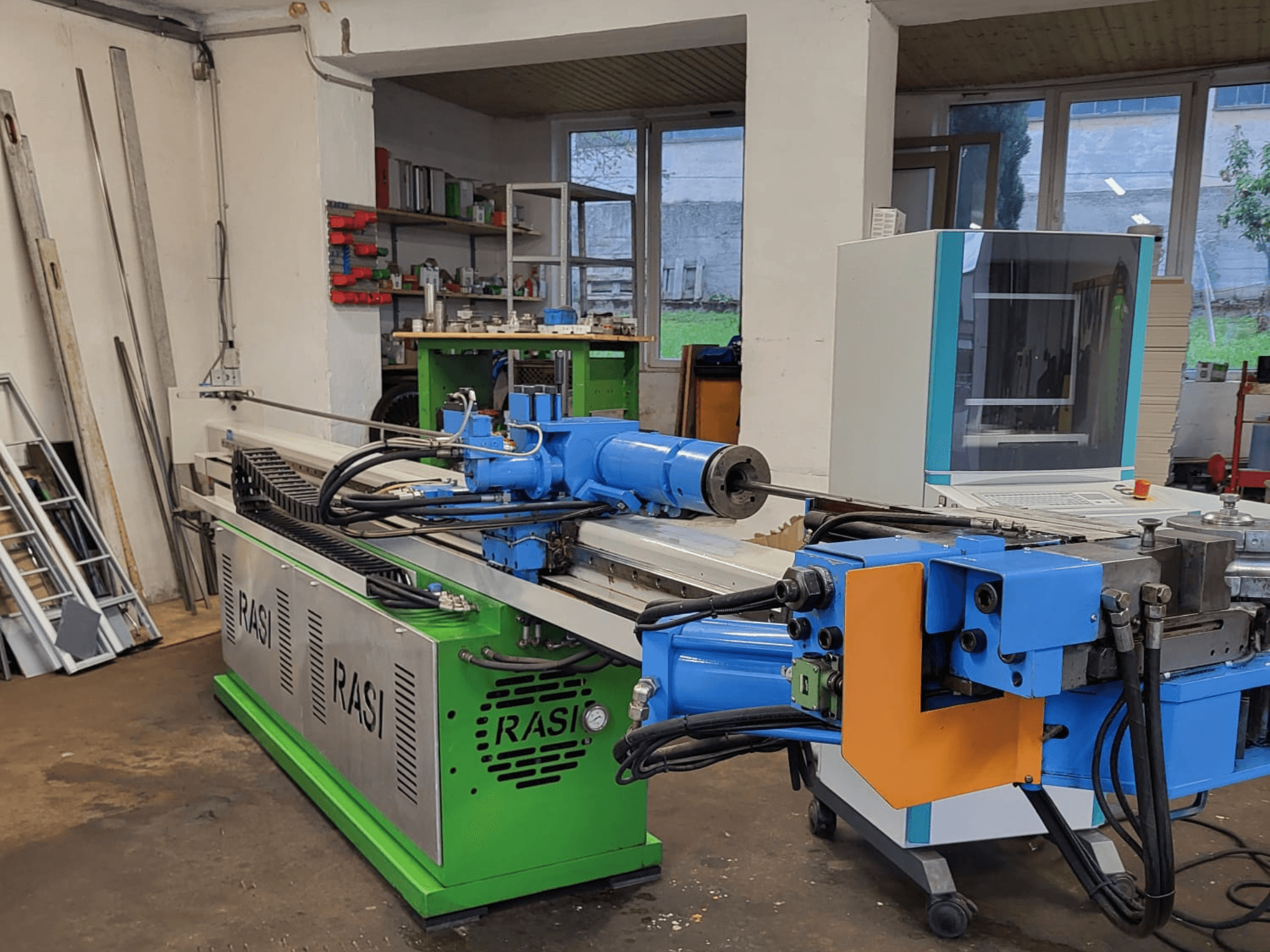 Rasi S 80.6 L G-V3C50 machine tool in a workshop setting, side view showing blue and green components and control panel.