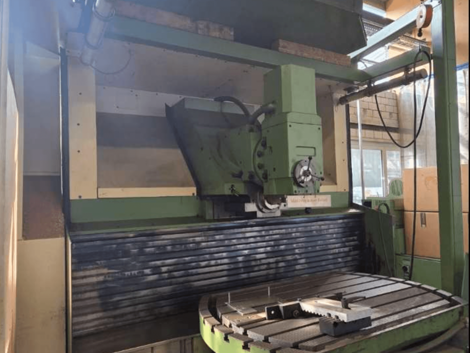 MAHO MH1000 C Universal Machining Centre in front view, showcasing green structure, spindle, and rotary table with a workpiece.