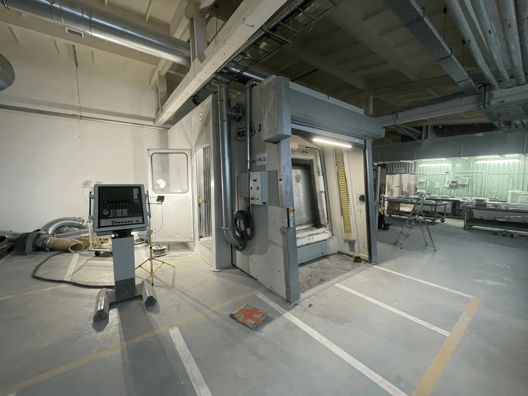 MAKA DC 3 vertical machining centre in a workshop, viewed from the front, featuring control panel and open door.