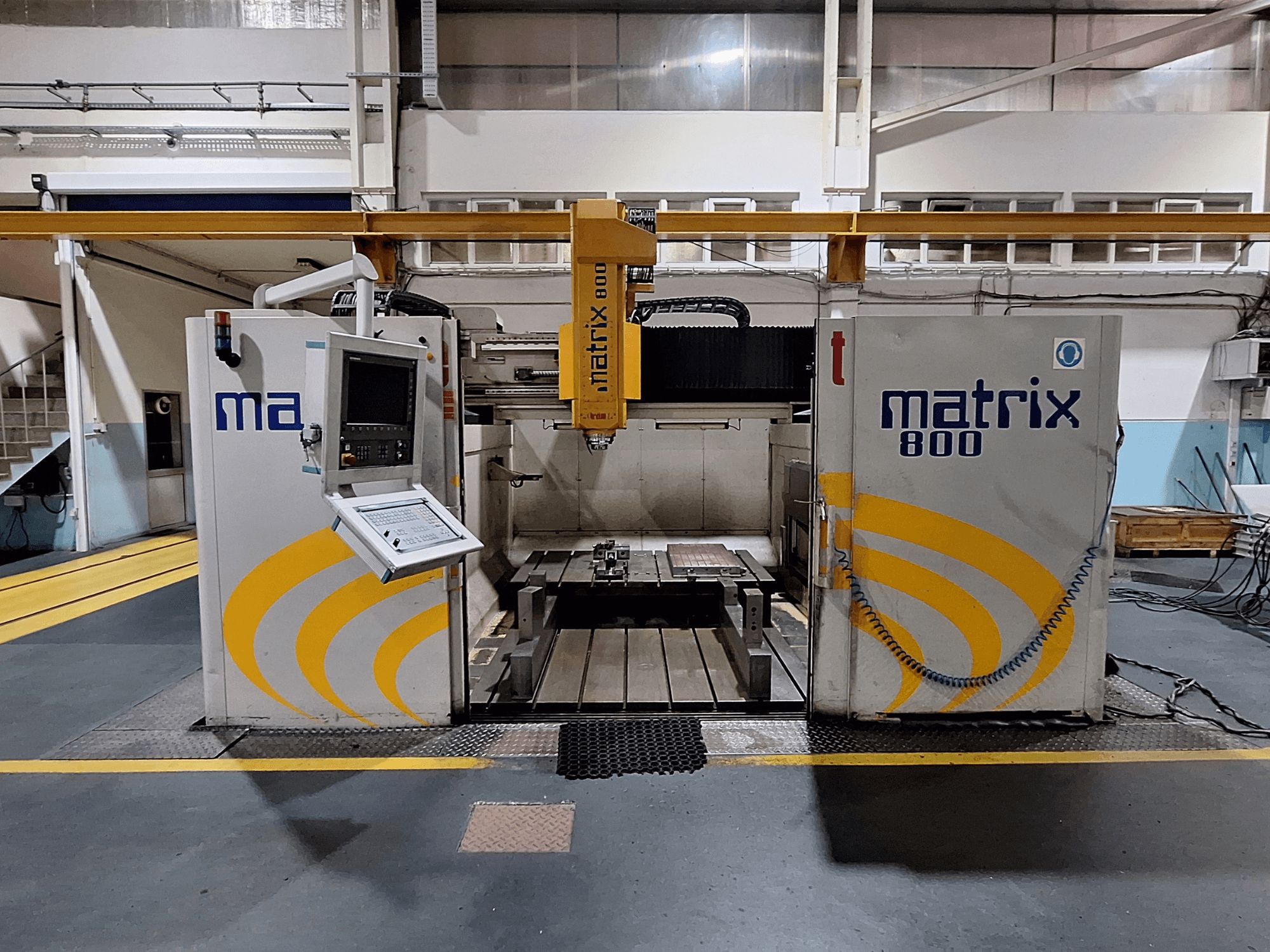 Gantry milling machine Breton Matrix WM 800 K25 in a workshop, showing control panel and worktable from the front view.