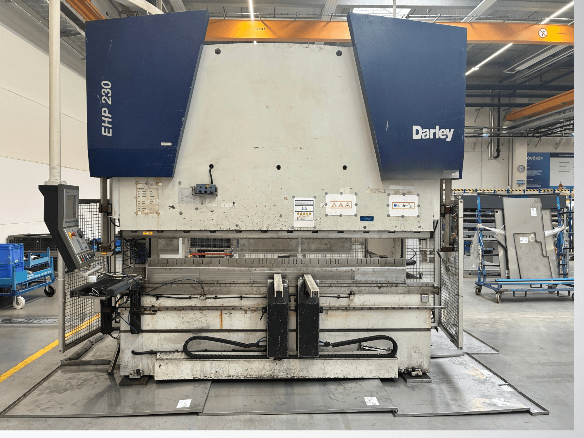 Hydraulic press Darley EHP-LS 230.31/25, front view, with control panel and metal sheets nearby. Ideal for industrial applications.