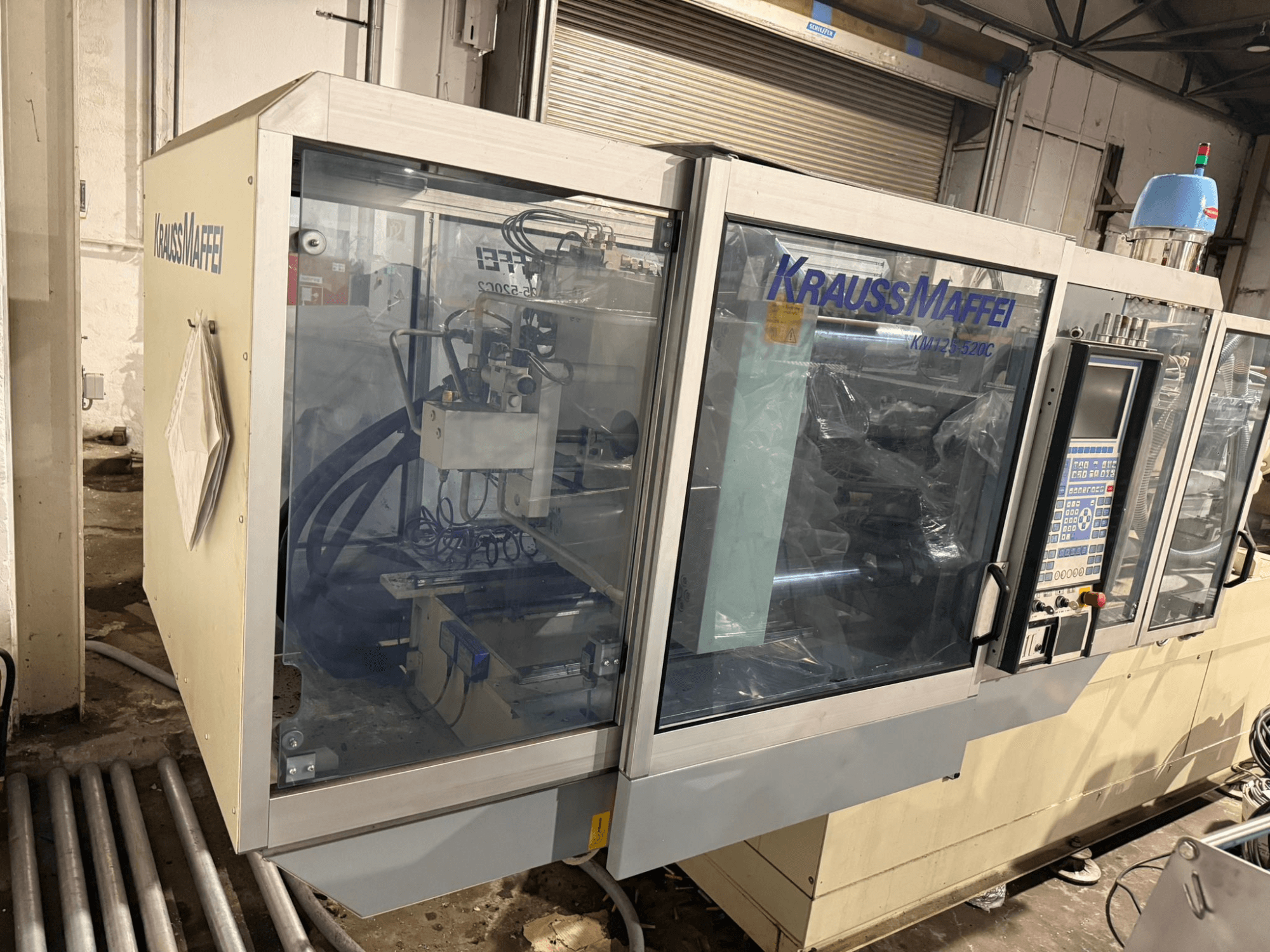 Krauss Maffei KM125-520C2 hydraulic injection moulding machine, front view with control panel and transparent casing.