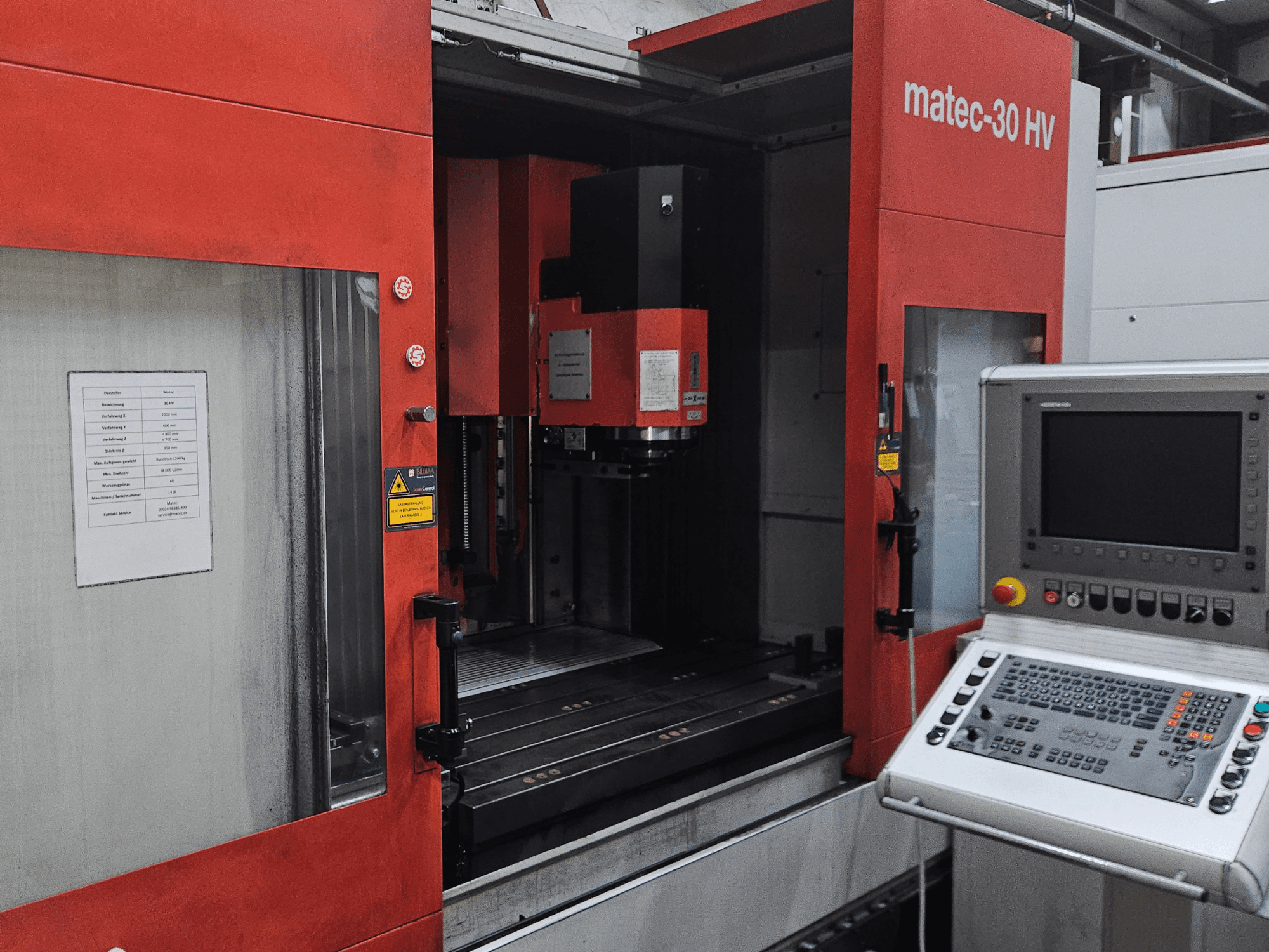 Front view of a Matec 30 HV vertical machining centre, displaying control panel and operational details on the machine.