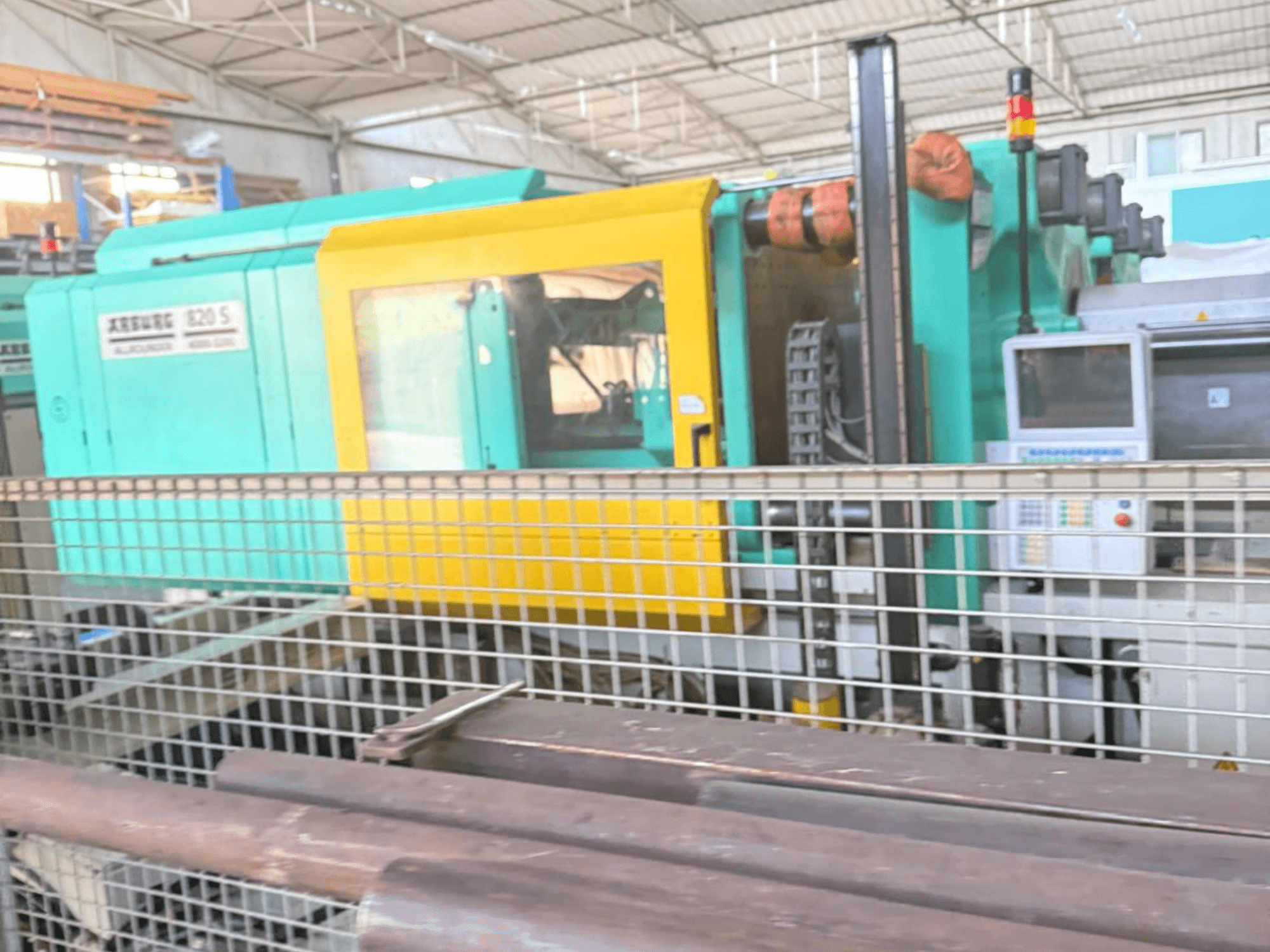 Hydraulic injection moulding machine Arburg SELECTA 820 S 4000-3200, side view, showcasing control panel and vibrant yellow and teal design.