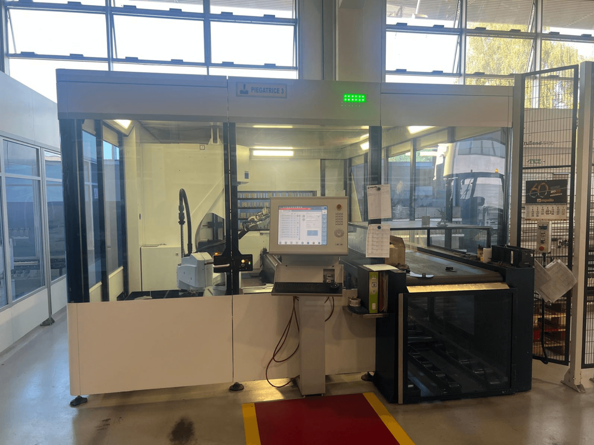 Industrial bending machine, model Piegatrice 3, front view with control panel and robotic arm, in a well-lit workshop setting.