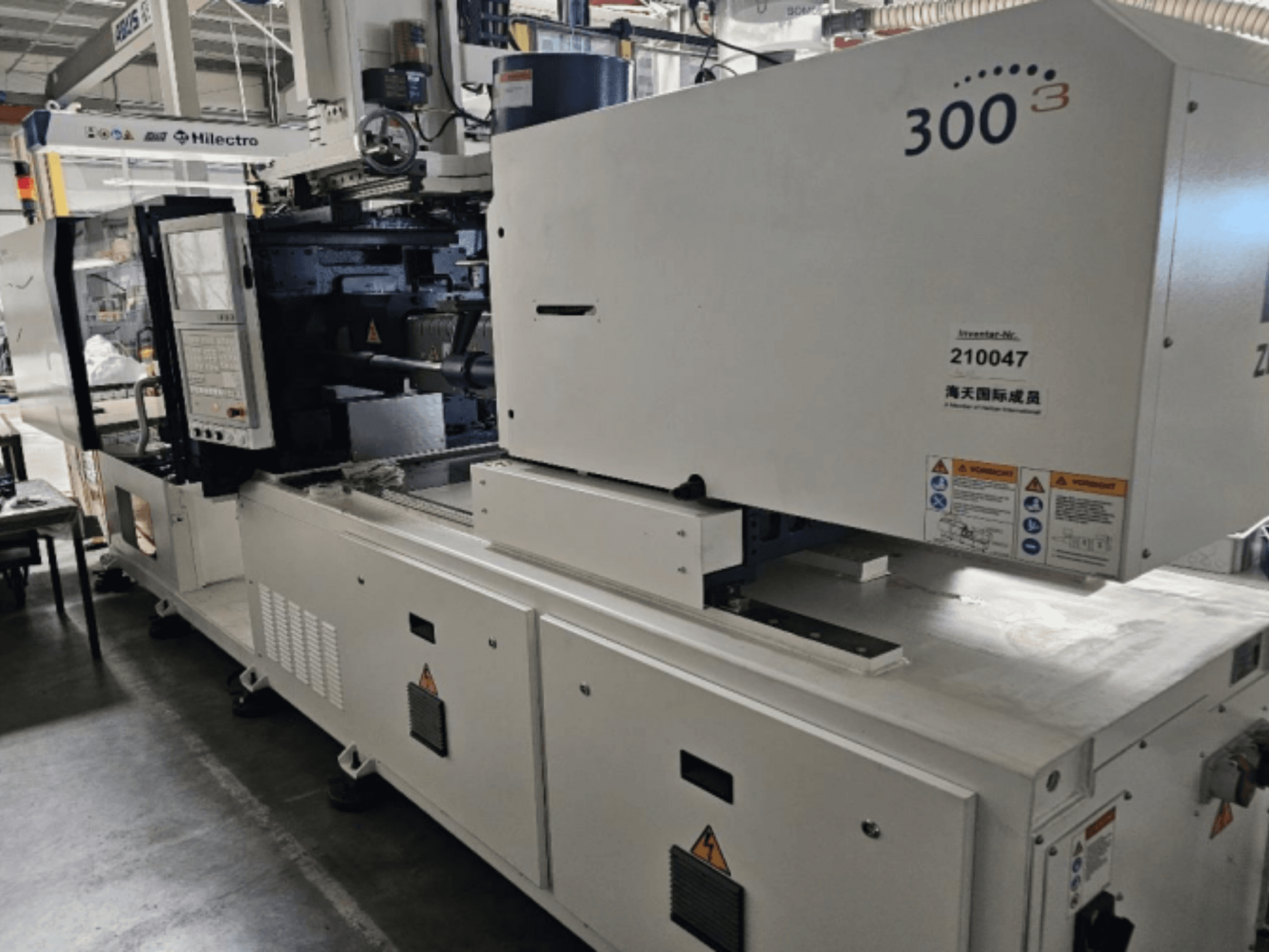 Injection molding machine, brand Zhenjing, model 300, front view with control panel and safety warning labels visible.