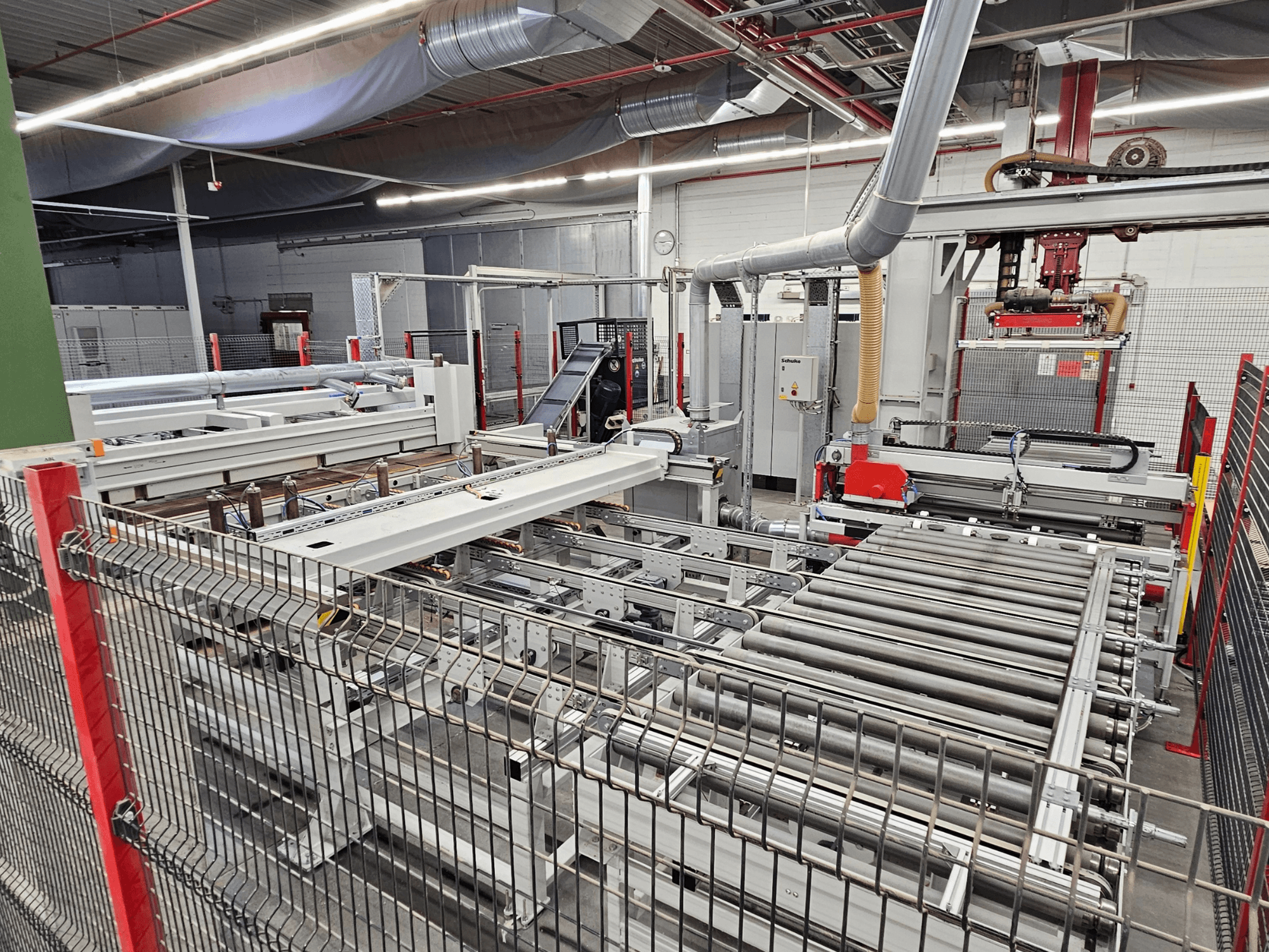 HOLZMA HPP81-3200 panel saw shown in a front view, featuring conveyor rollers and machinery components in a workshop setting.