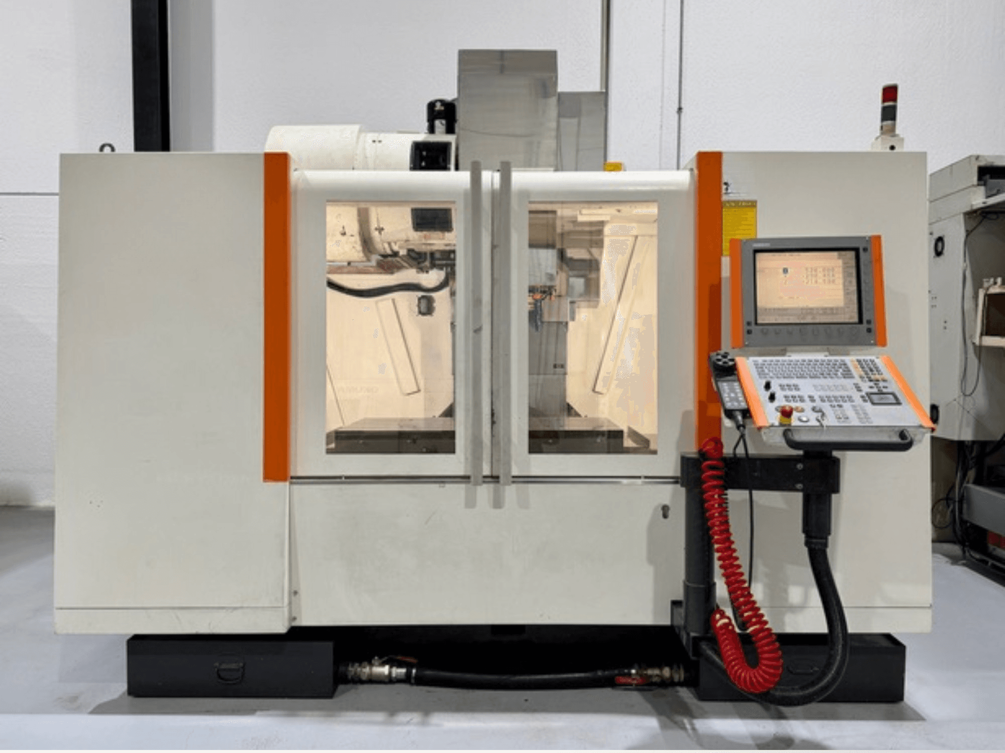CNC machine with orange accents, front view. Includes control panel and visible interior workings.