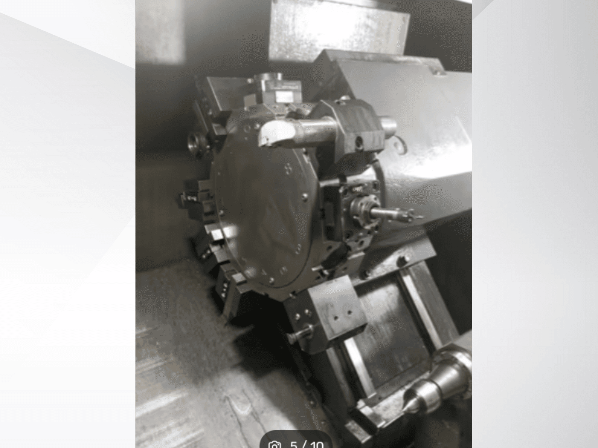 Close-up of a precision machine part, showing gears and metal components, viewed from an angled perspective. No brand visible.