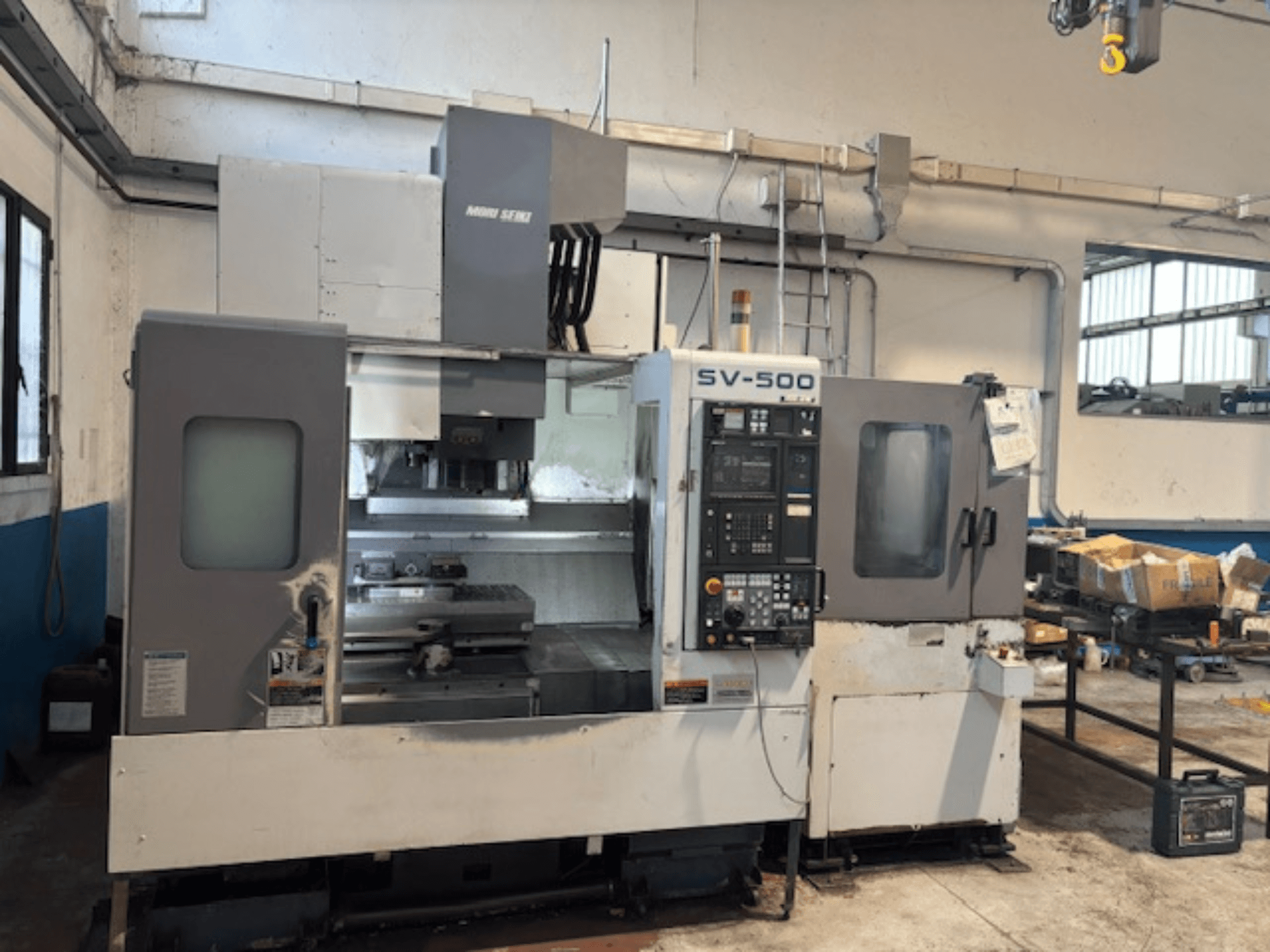 MORI SEIKI SV-500/40 vertical machining center in a workshop, front view showcasing control panel and machining area.