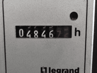 Legrand hour meter showing 048467.6, front view with red indicator light and black digits on a textured light background.