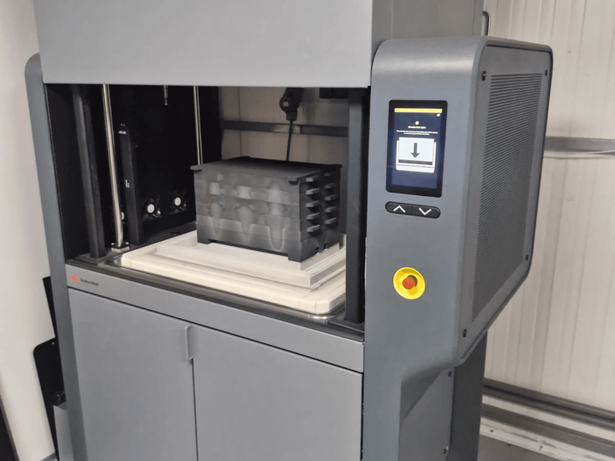 Metal Studio 2 3D printer by Desktop Metal, front view showing control panel and print bed with a black container.