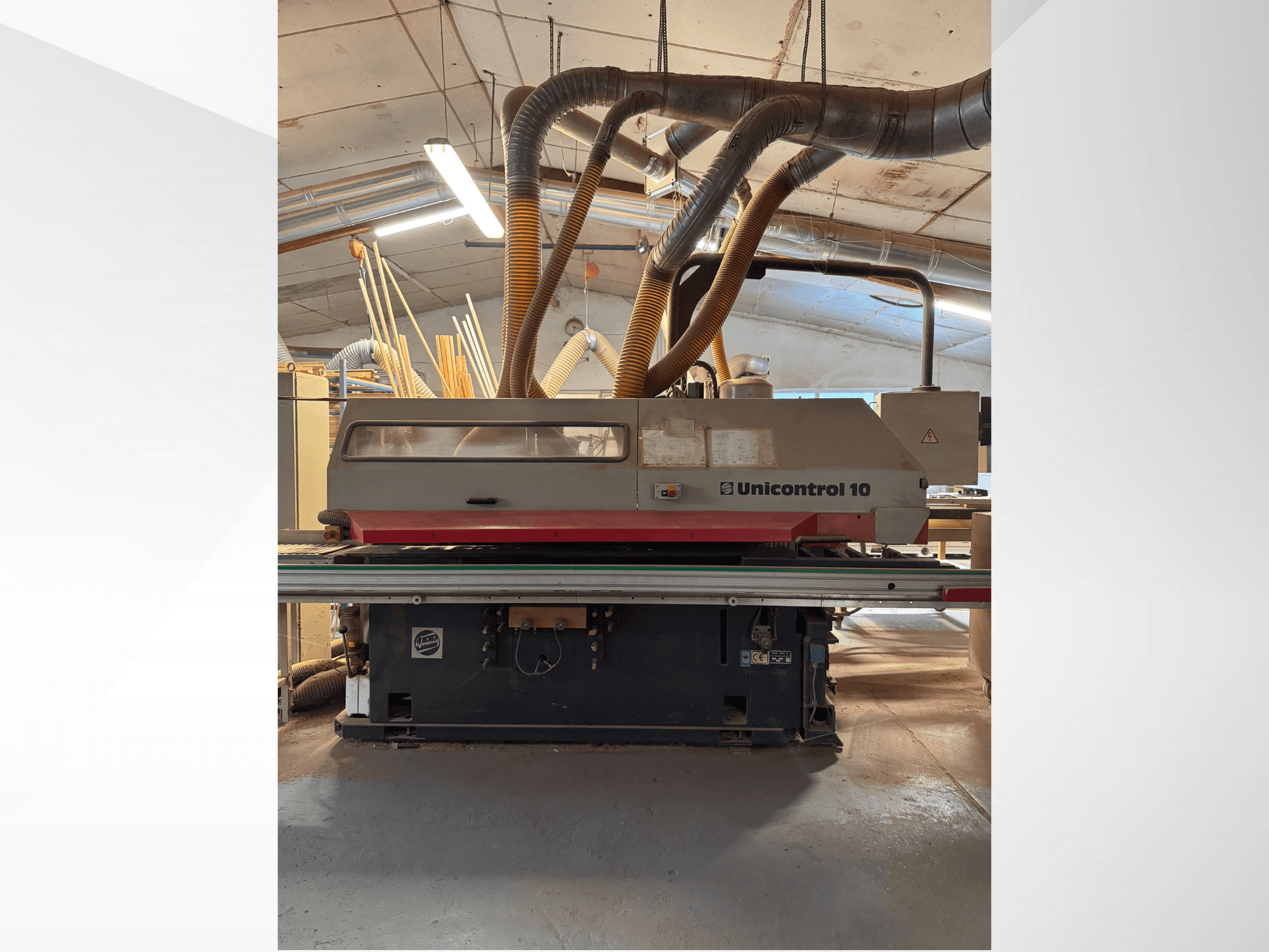 Front view of a Unicontrol 10 woodworking machine, featuring dust extraction tubes and operational controls.