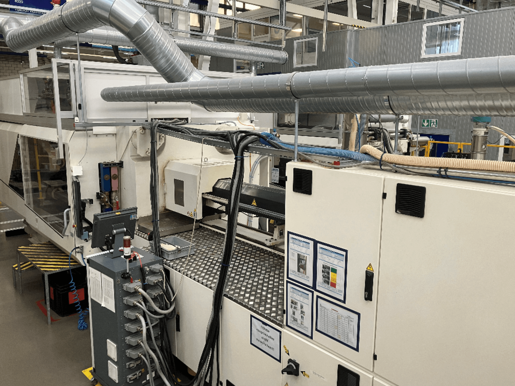 Industrial machinery with extensive piping, control panel, and operation manuals, viewed from a top-down perspective.