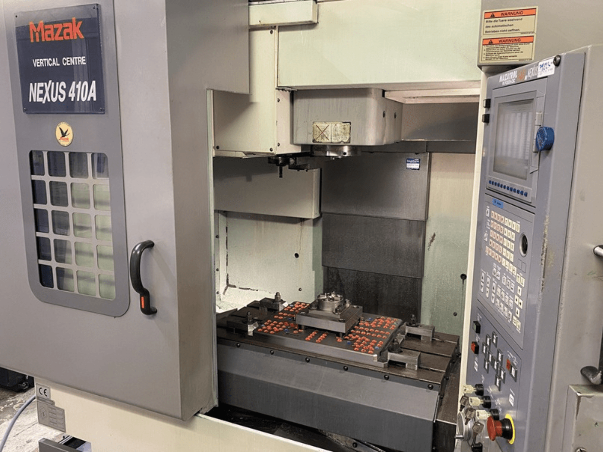 Mazak NEXUS 410A Vertical Machining Centre, front view, with visible control panel and machine tool setup on the workspace.