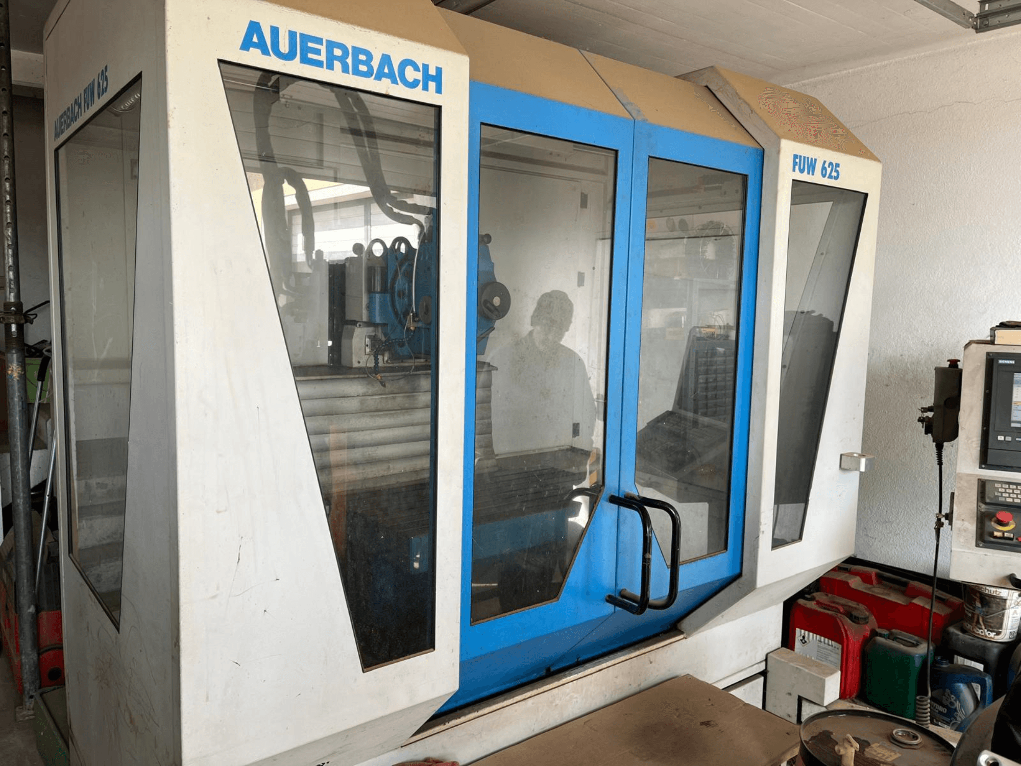 Auerbach FUW 625 Universal Machining Centre in side view, featuring glass panels and a control panel on the right.