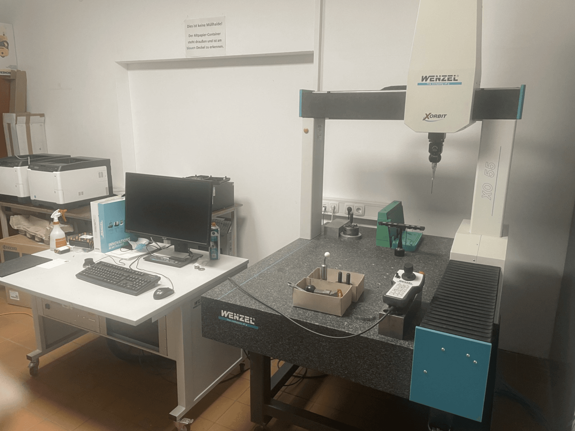 Wenzel XO 55 Coordinate Measuring Machine with green tools on a granite table, viewed from the front with a computer station.