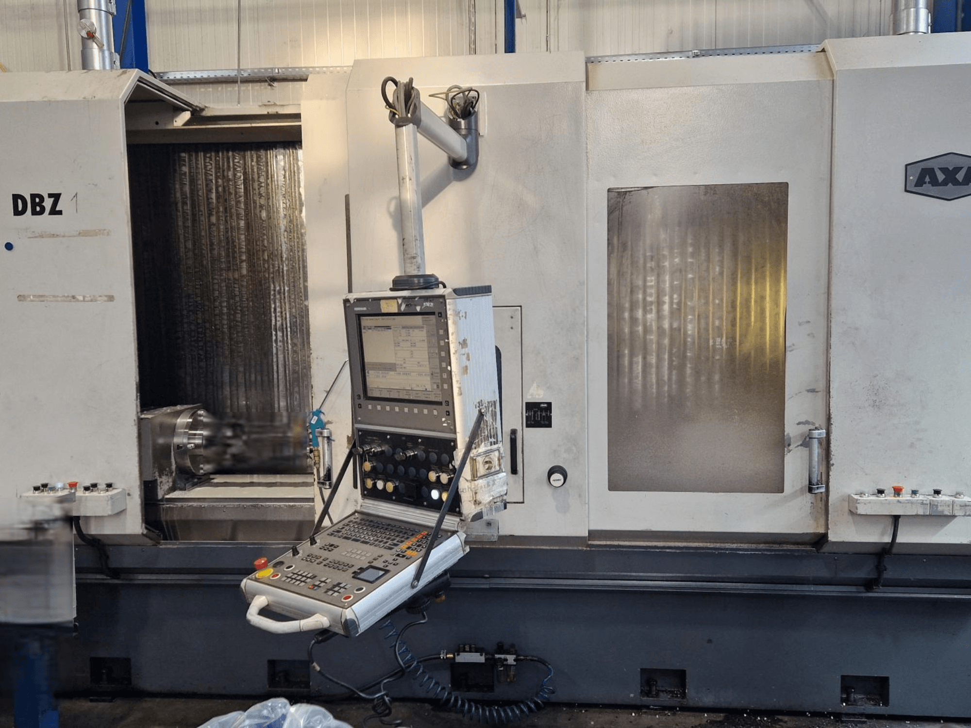 AXA DBZ Vertical Machining Centre shown from an angled front view, featuring a control panel and visible cutting tool area.