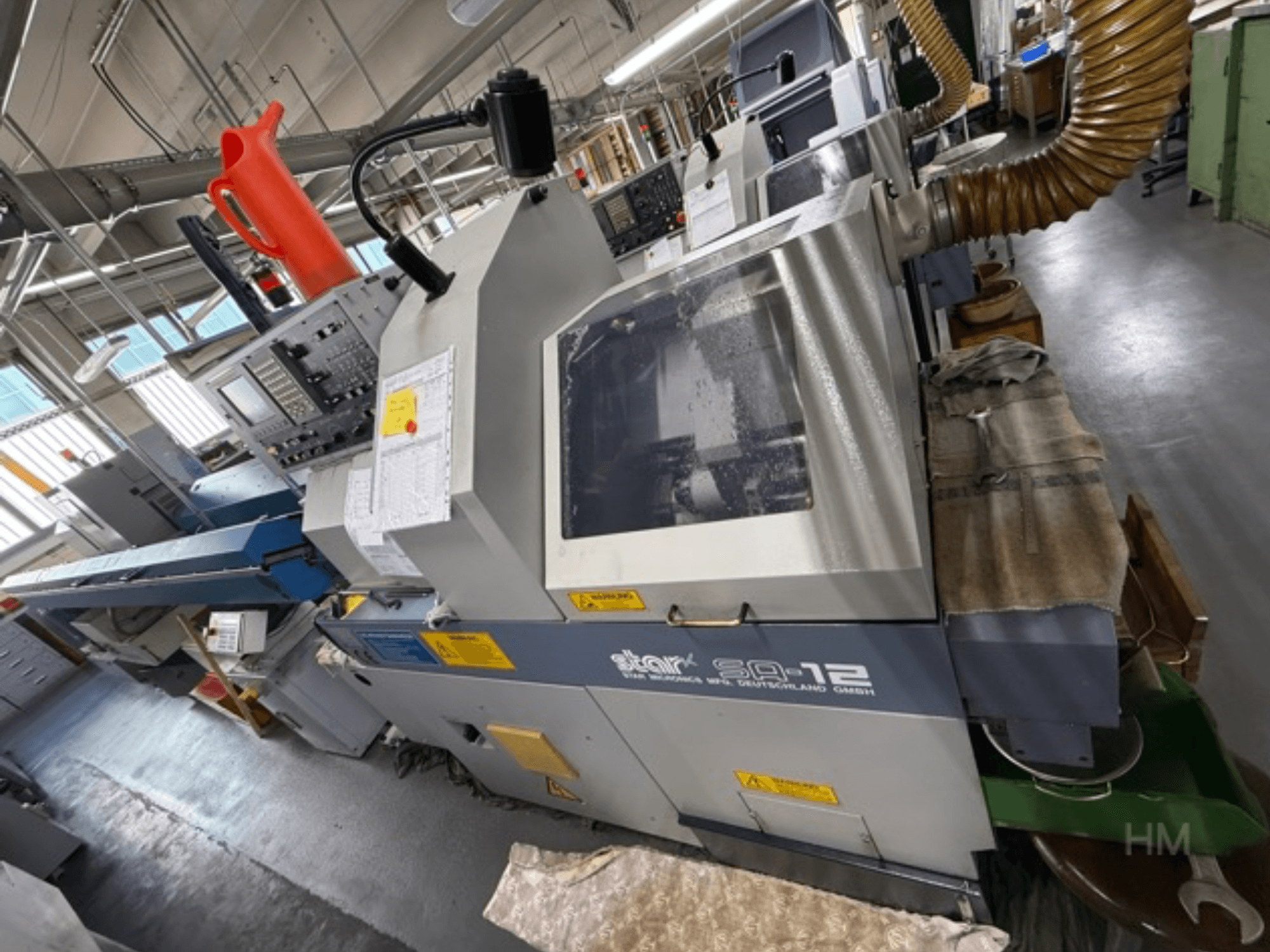 Star SQ-12 machining center, side view with control panel, coolant container, and dust extraction hose visible.