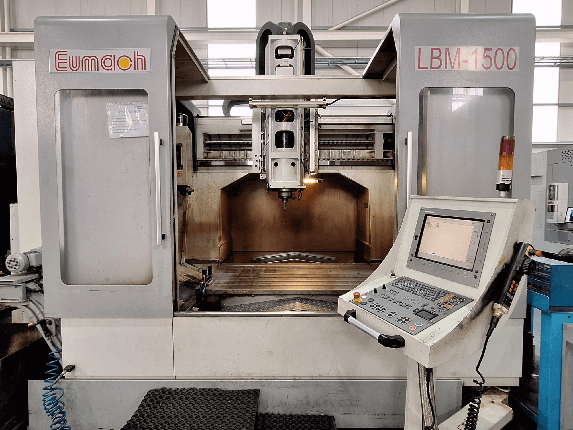 Eumach LBM-1500 bed type milling machine, front view, showing machining area and control panel with buttons and display.